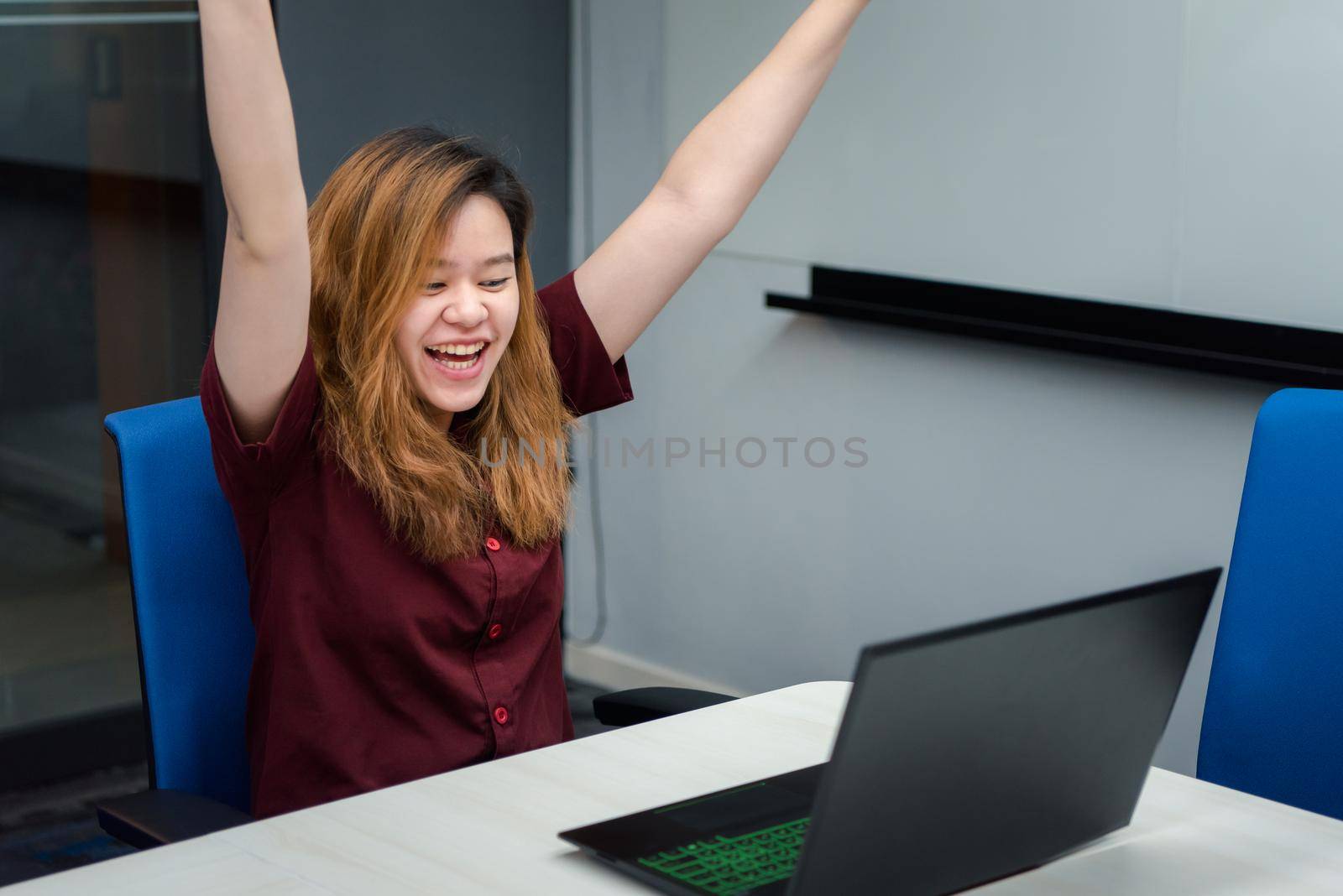 Asian woman is student, businesswoman working by computer notebook, laptop in office meeting room with whiteboard in background with happy and relax emotion in concept working woman, success in life