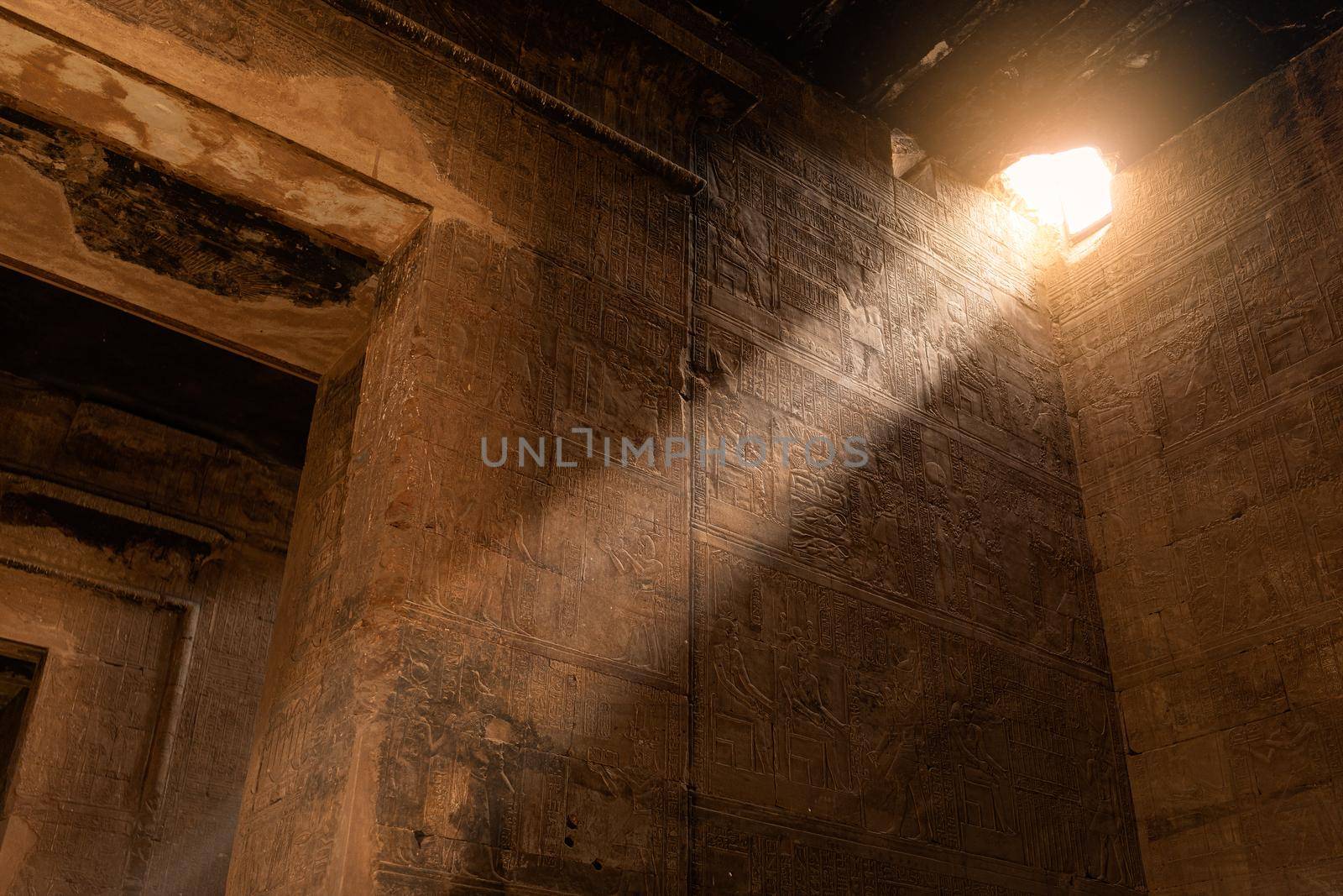 Ray of a sun entering through a breach in the Egyptian temple of Edfu