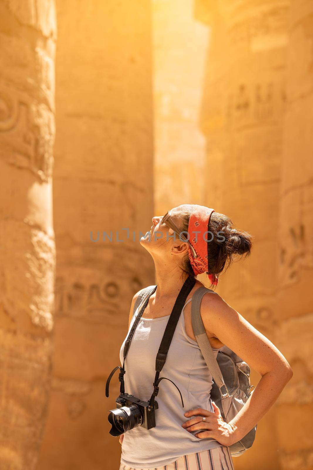 Tourist looking up to columns with hieroglyphs in a temple in Karnak in Egypt