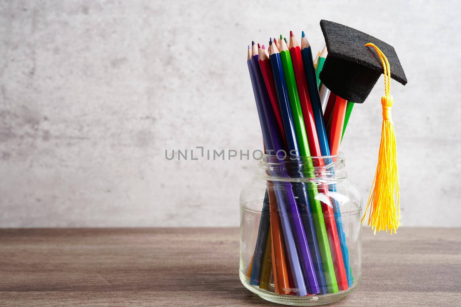 Graduation hat with colorful pencils on book with copy space, learning university education concept.