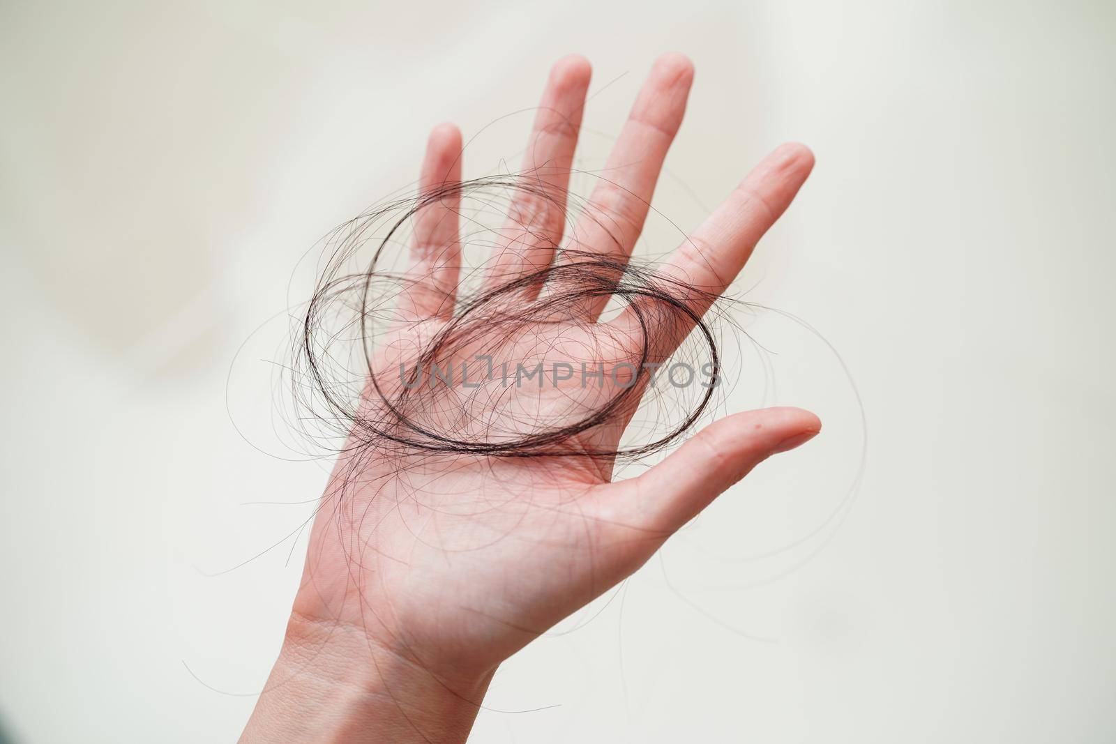 Asian woman have problem with long hair loss attach in her hand.