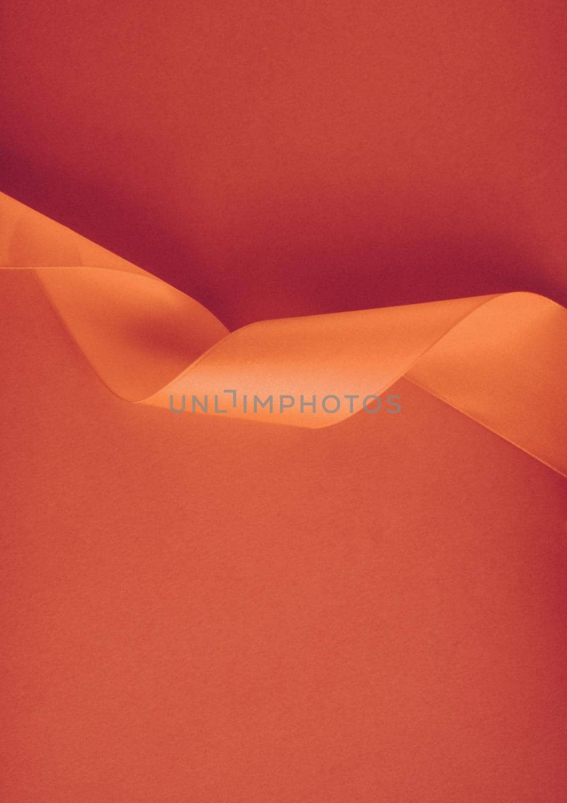 Branding, holidays and luxe brands concept - Abstract curly silk ribbon on orange background, exclusive luxury brand design for holiday sale product promotion and glamour art invitation card backdrop