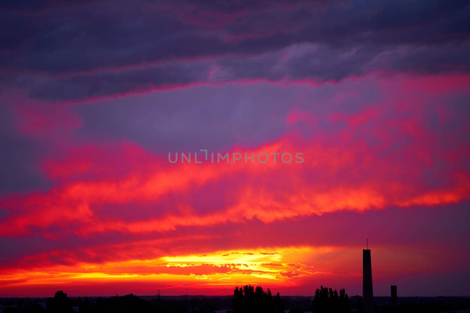 Fiery summer sunset landscape. Orange sun and dark blue sky.