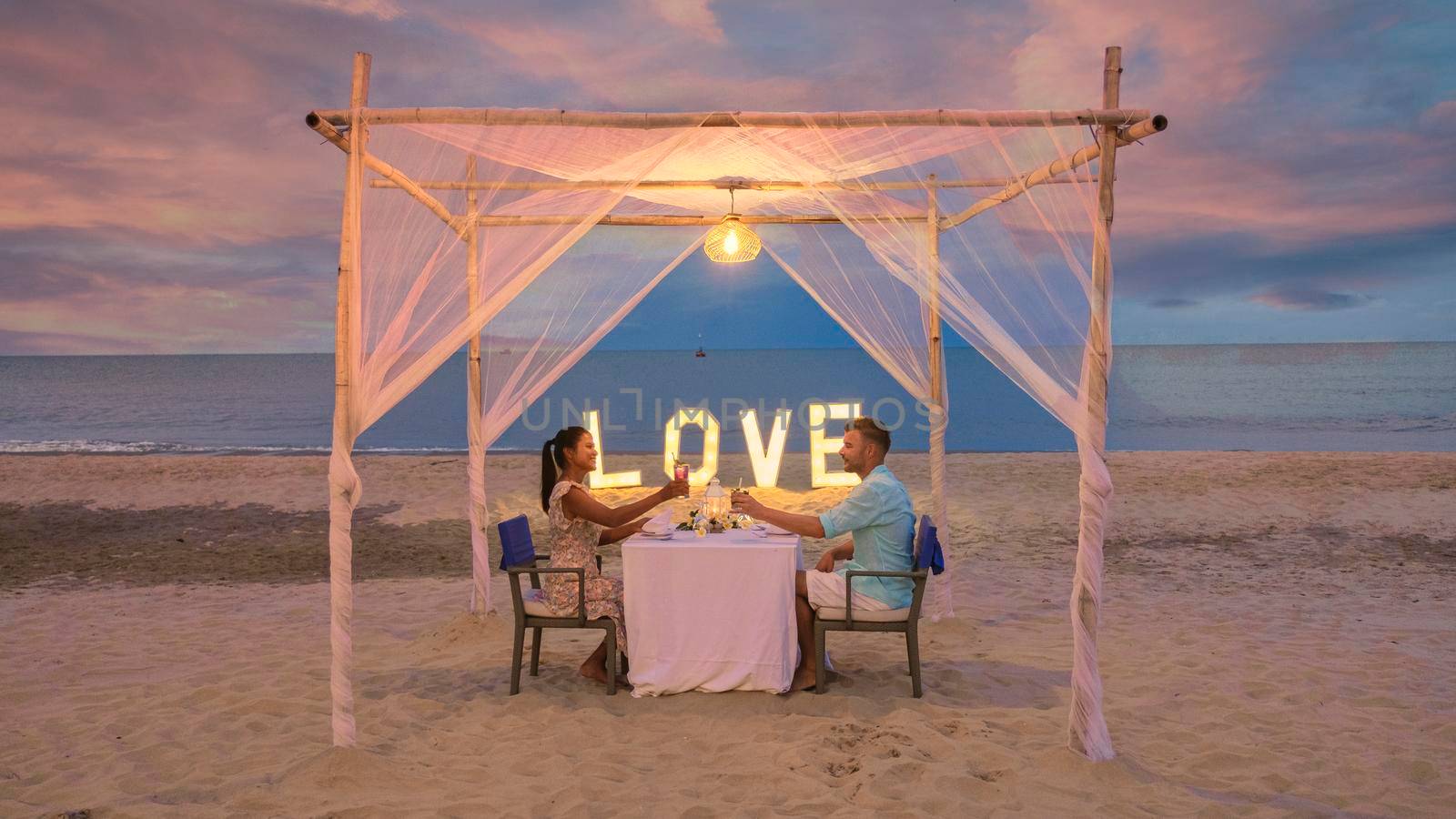 Romantic dinner on the beach of Huahin Thailand, dinner by candlelight in Hua Hin, Valentine's concept. Couple of men and women having a romantic dinner on the beach in Thailand