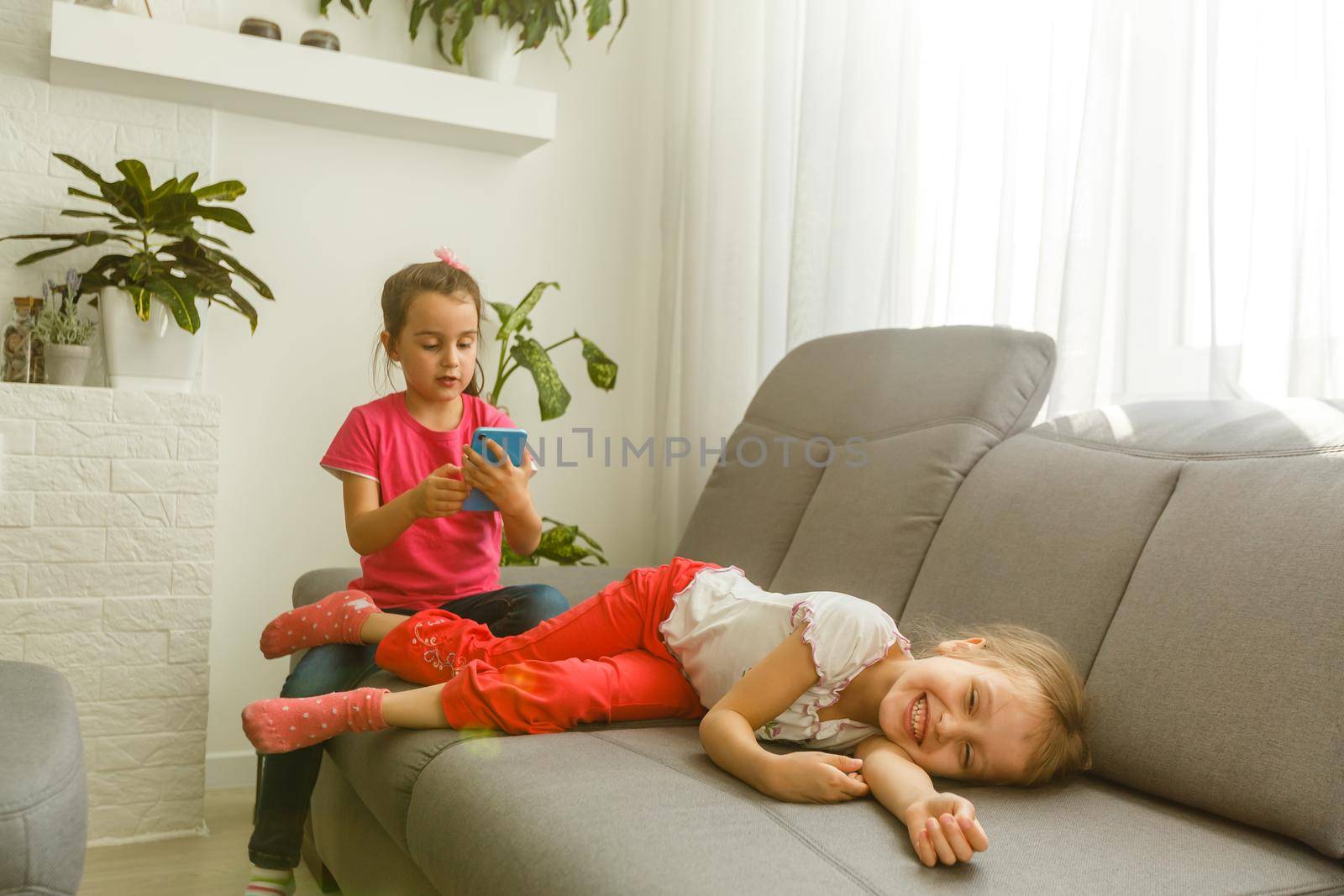 Two little girls are playing at home. Childhood