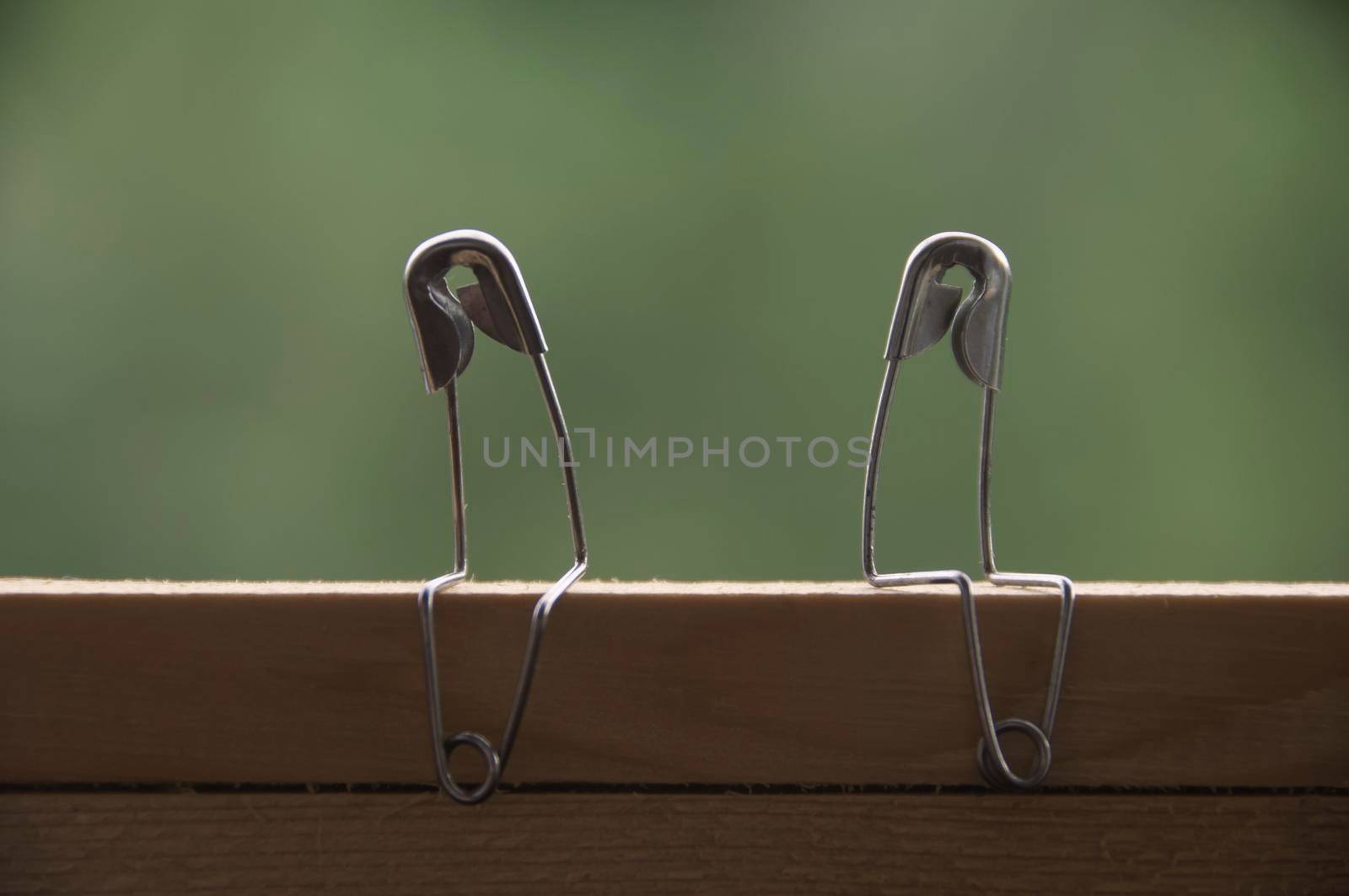 Safety pin couple sitting on table ignoring each other. Conflict and romance concept.