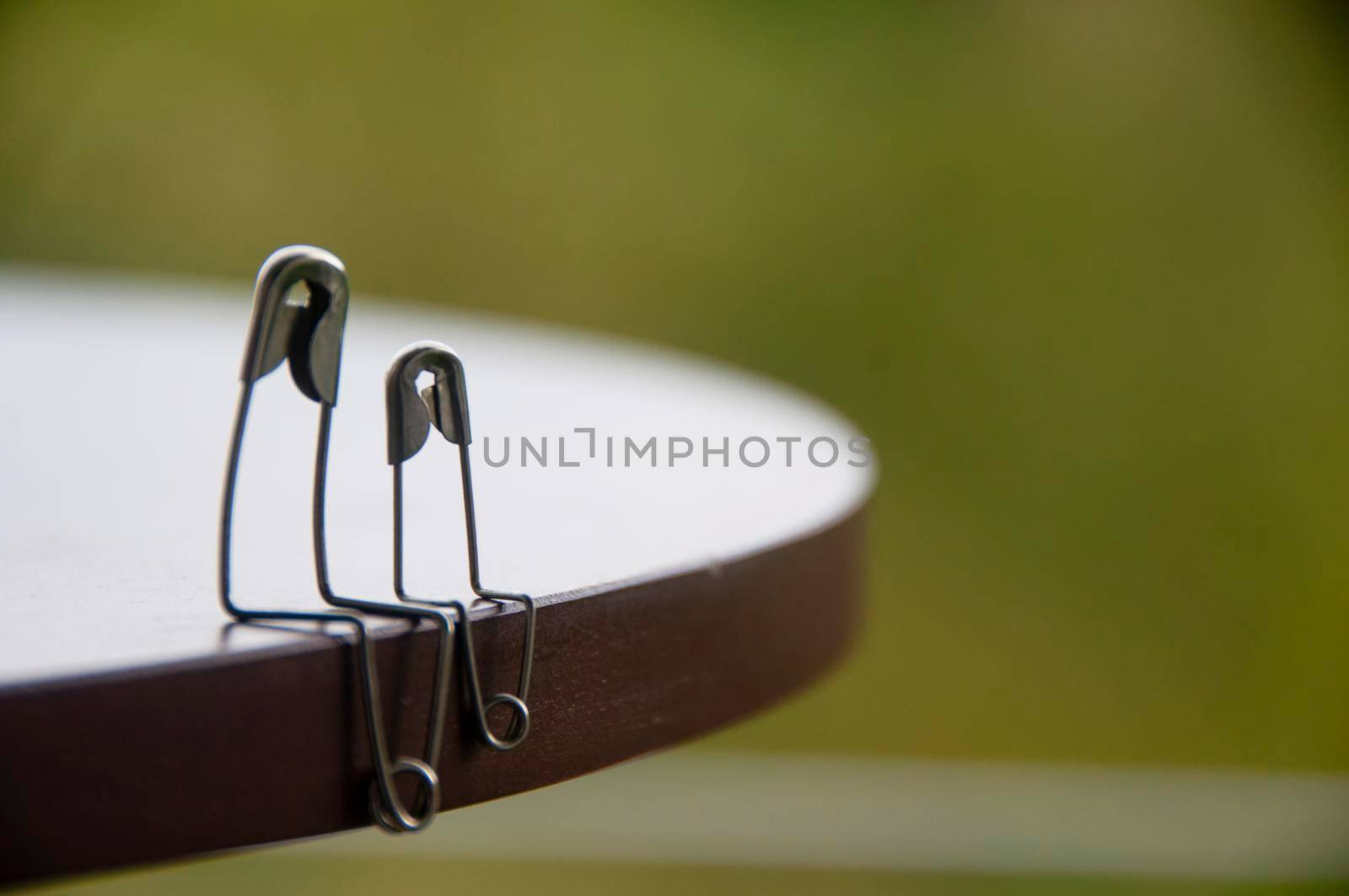 Model safety pin of parent and children sitting on wooden table with customizable space for text or ideas. Family concept.