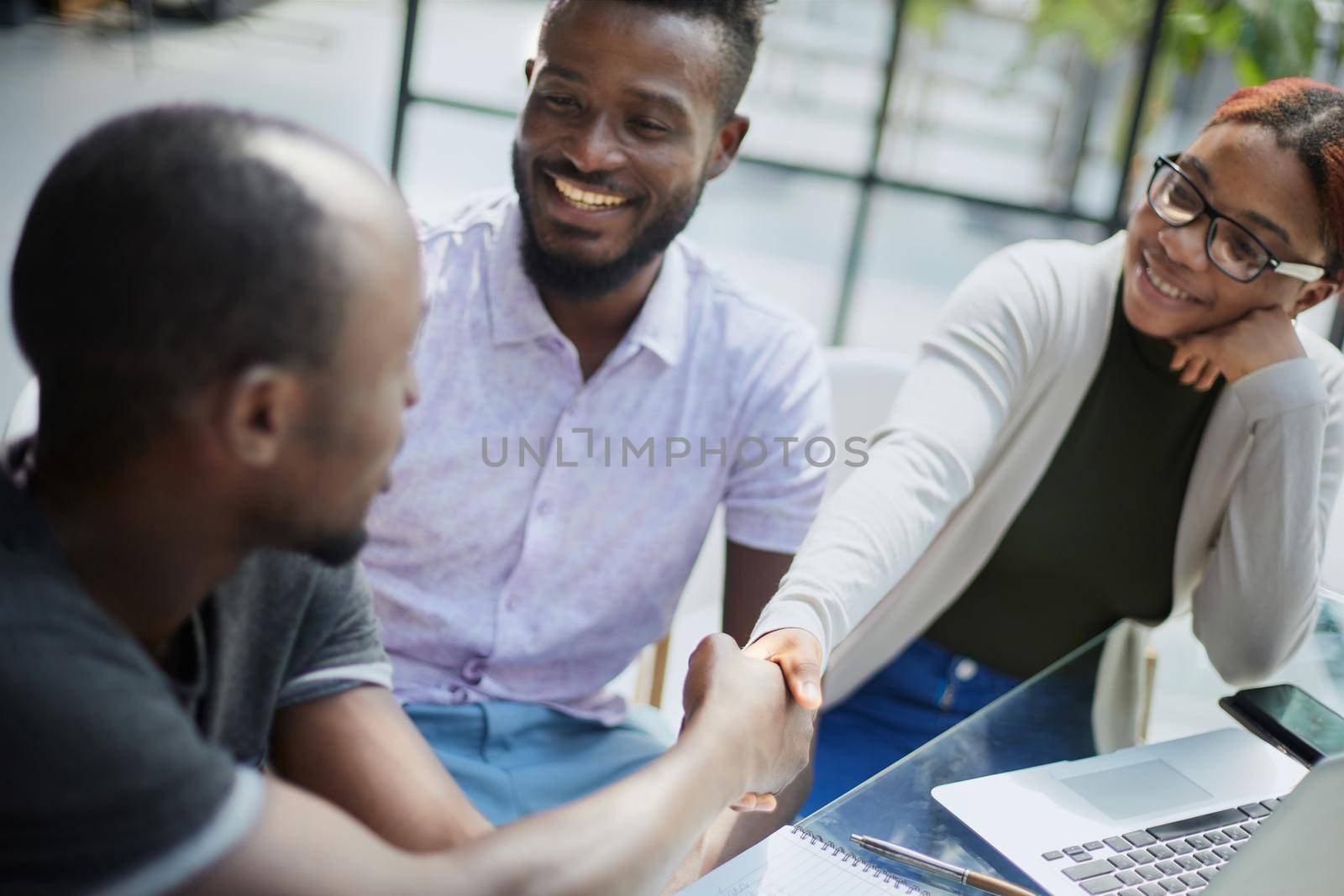 african business people handshaking at modern office by Prosto