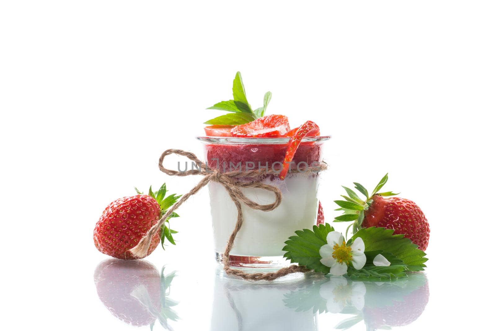 sweet homemade yogurt with strawberry jam and fresh strawberries in a glass, isolated on white background.