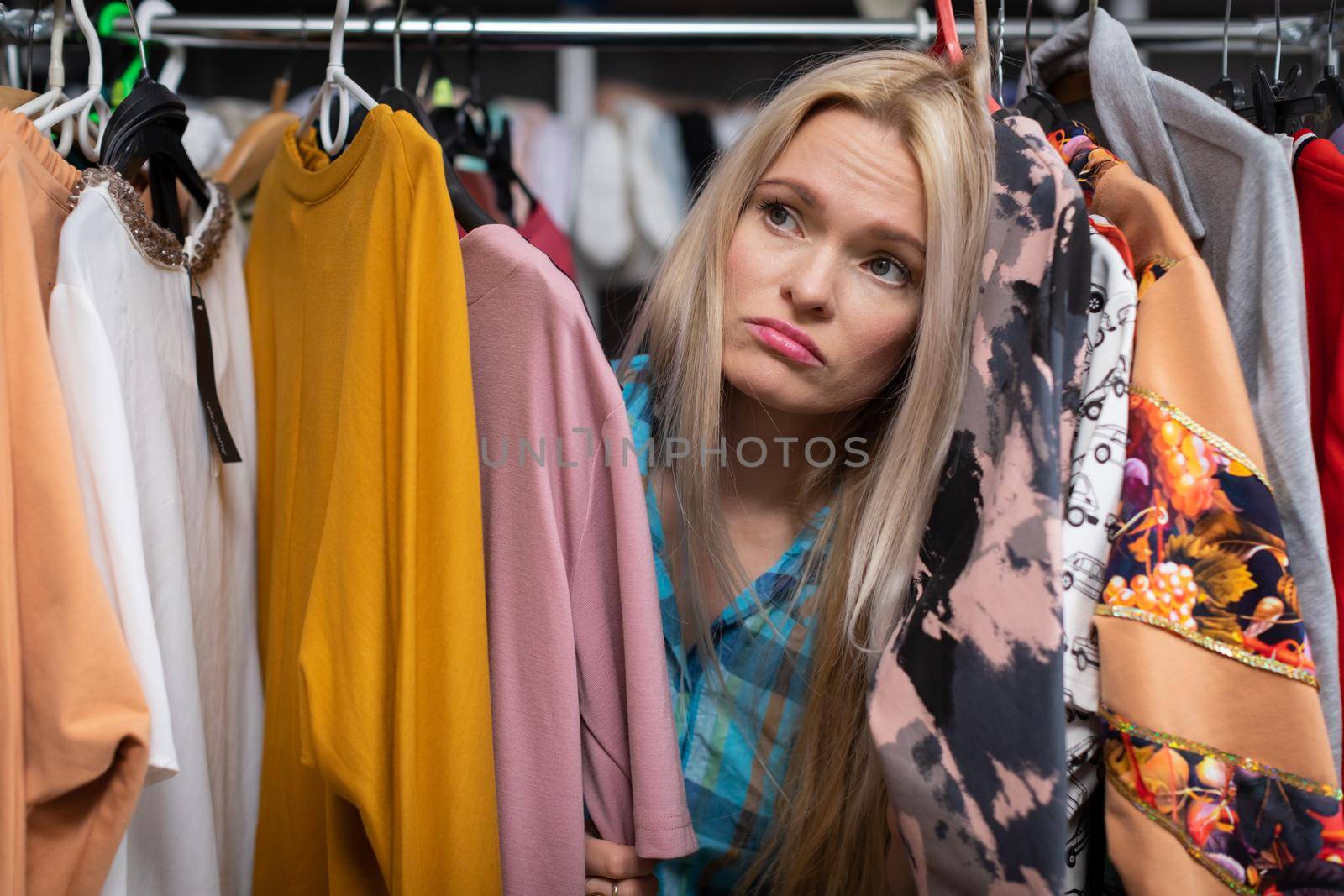 Unsuccessful shopping and dissatisfaction on the face of a lovely woman. Sadness on her face. Blonde hair with straight long hair. Light complexion of skin.