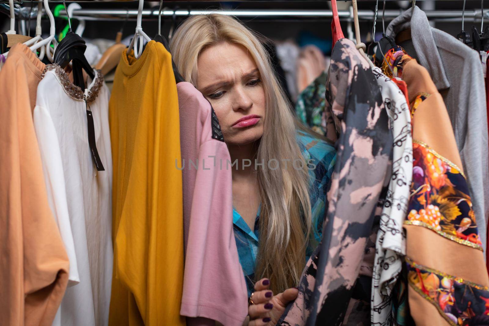 Unsuccessful shopping and dissatisfaction on the face of a lovely woman. Sadness on her face. Blonde hair with straight long hair. Light complexion of skin.