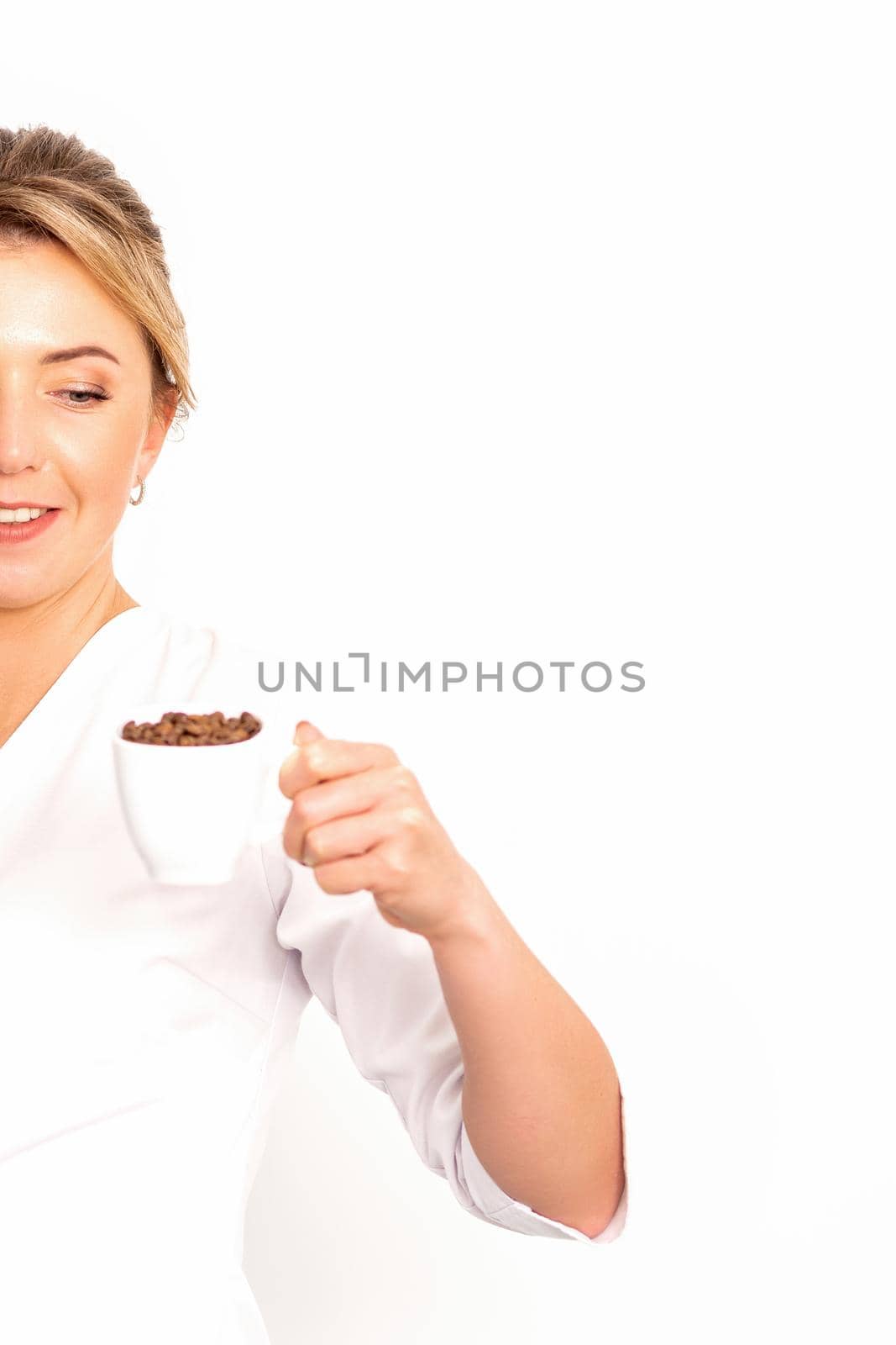 Cup of coffee beans. The female nutritionist holds a cup of coffee beans in her hand on white background