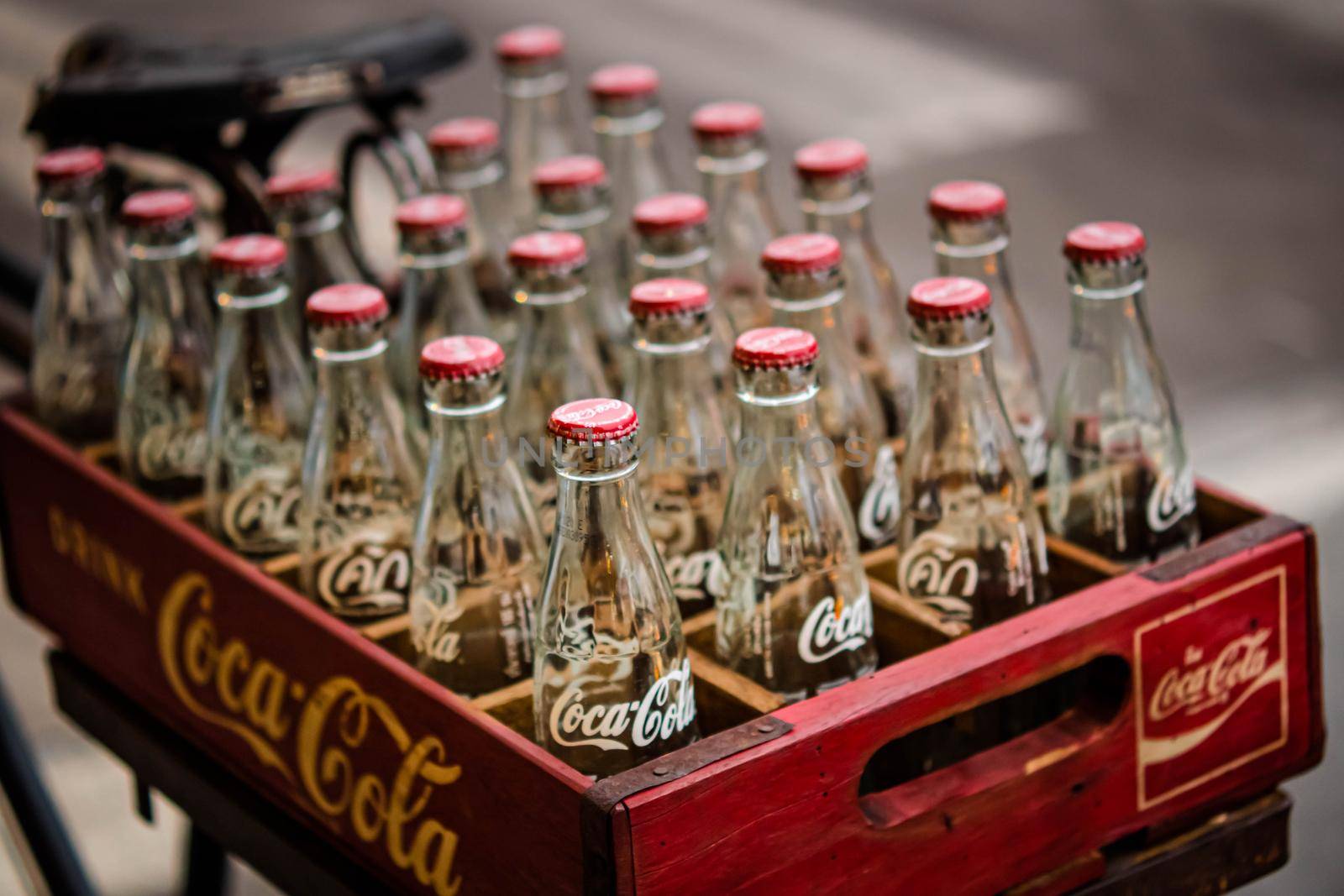 2020 June Bangkok Thailand. Vintage Coca-Cola clear glass bottle in Red Plastic Box carry on bicycle.