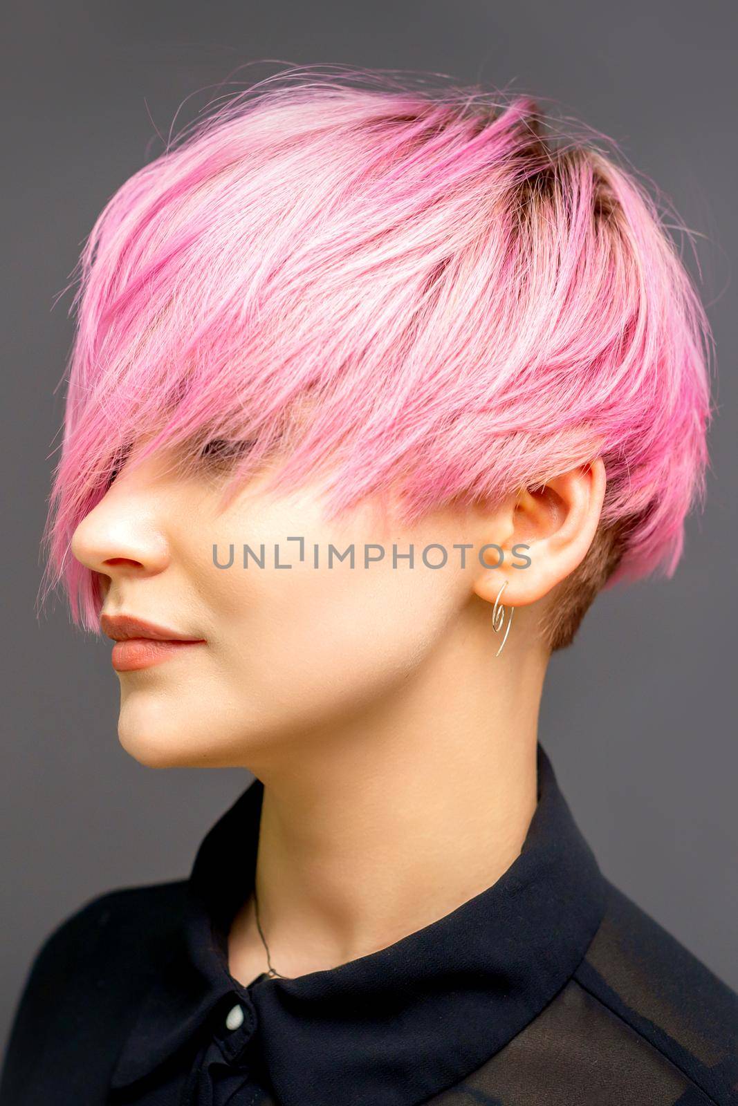 Profile of a beautiful young caucasian woman with short straight bob hairstyle dyed in pink color with closed eyes with copy space