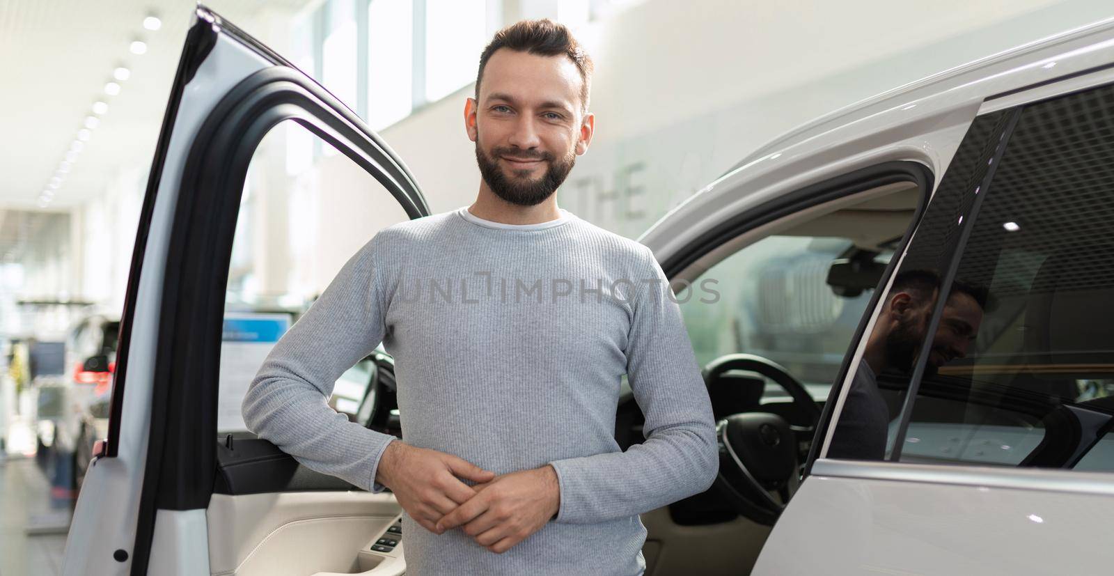new car buyer happy in car showroom next to suv.