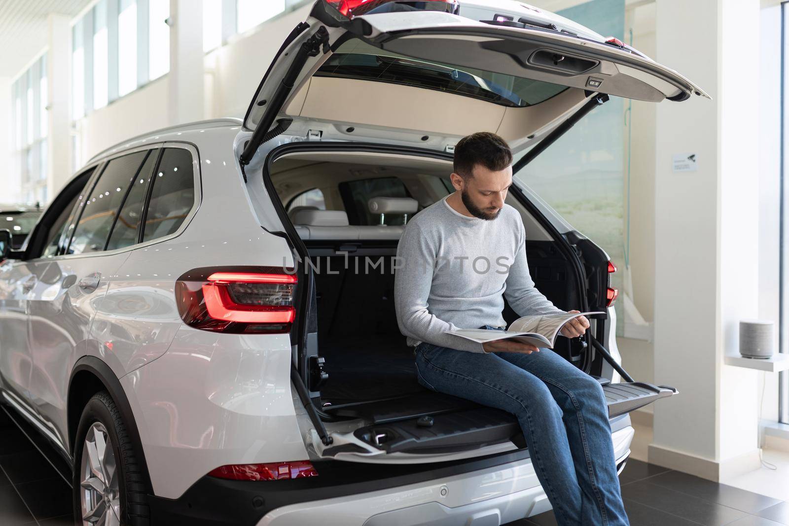 a family man in a car dealership draws up an insurance policy for a new purchased car.