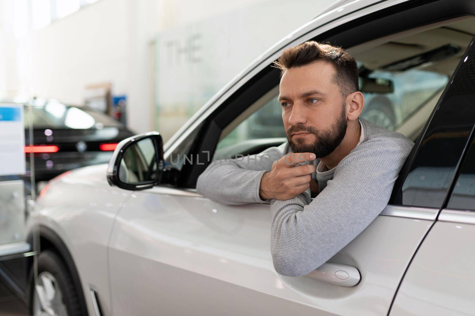 a man, when buying a new car in a car dealership, thought about an insurance policy for a driver from his family.