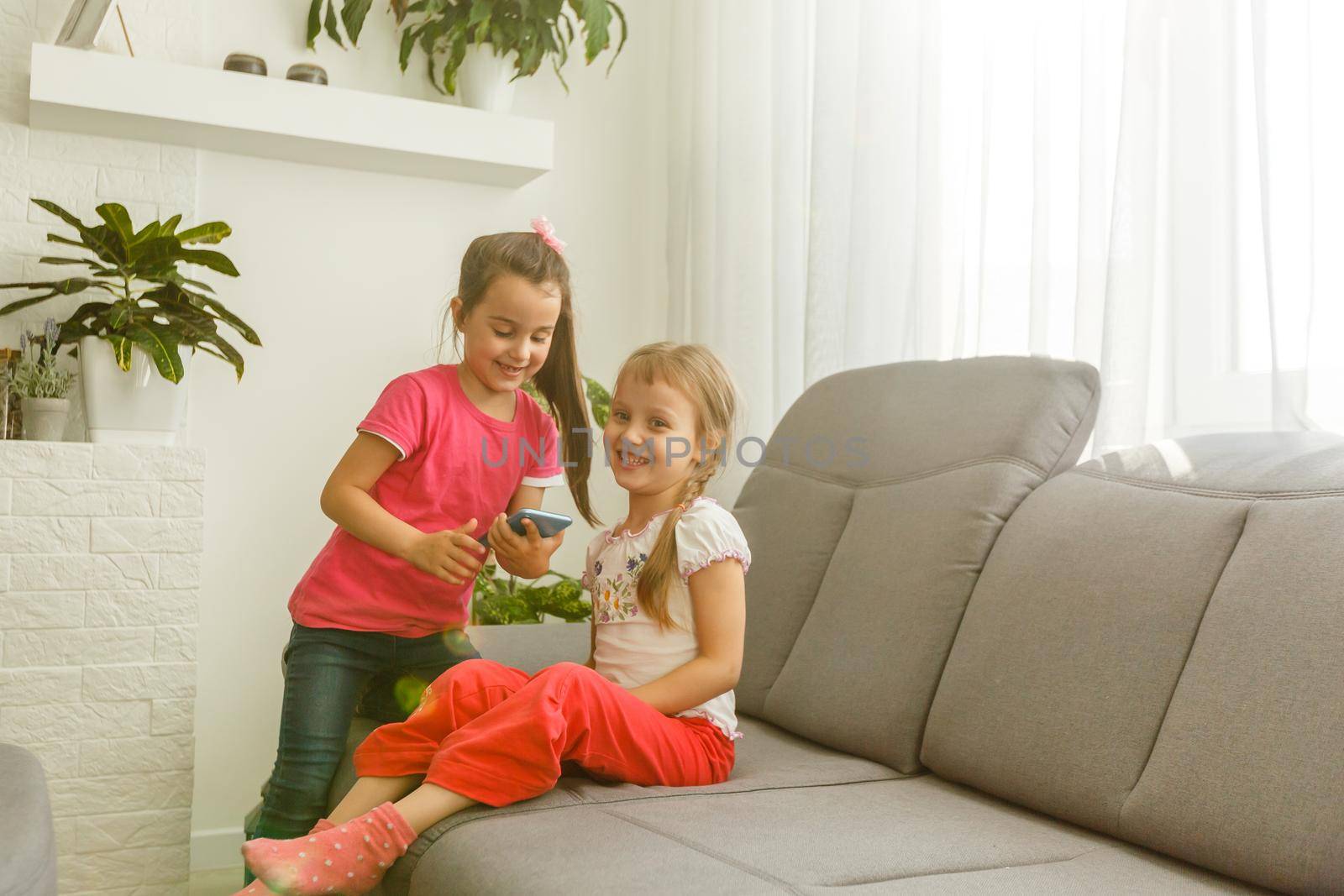 Two little girls are playing at home. Childhood