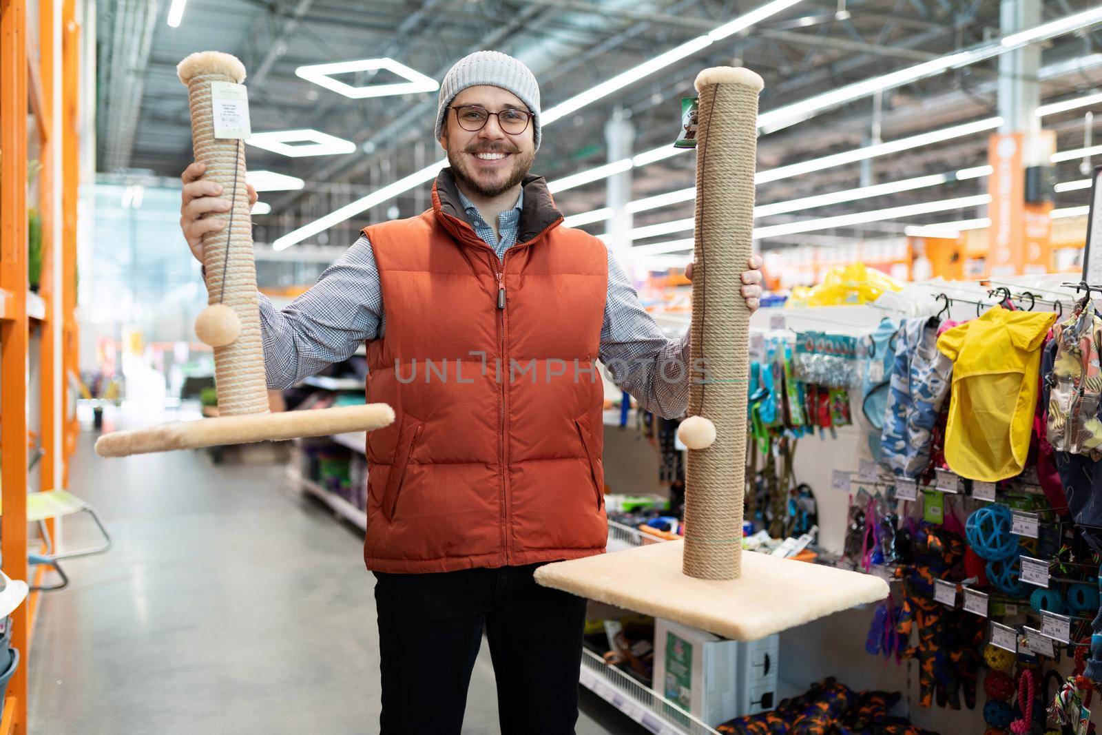 caring owner picks up a scratching post for his pet cat.