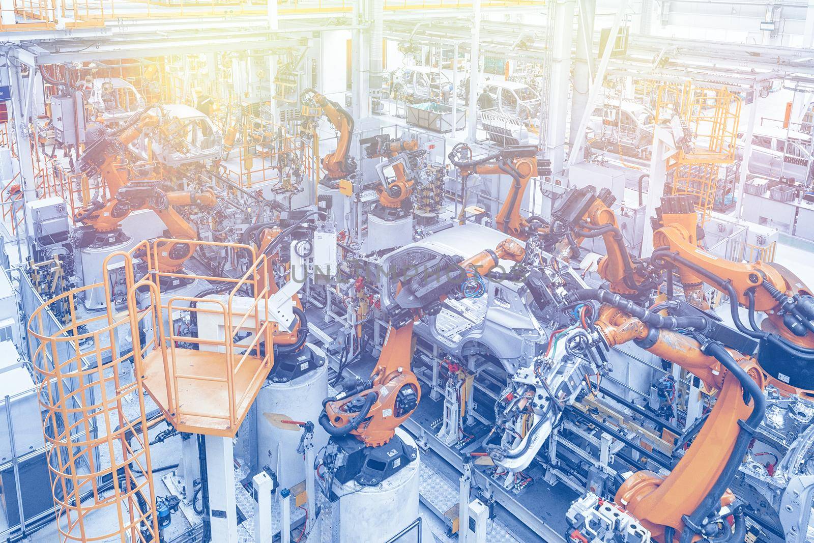 Photo of automobile production line. Welding car body. Modern car assembly plant. Top view in blue and yellow tone.