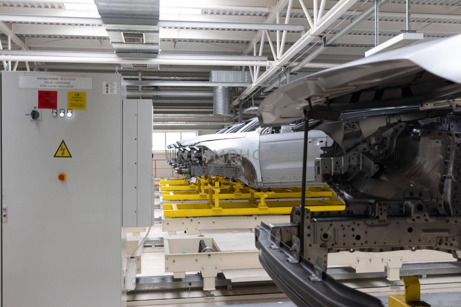 Car bodies are on assembly line. Factory for production of cars. Modern automotive industry. Plant concept.