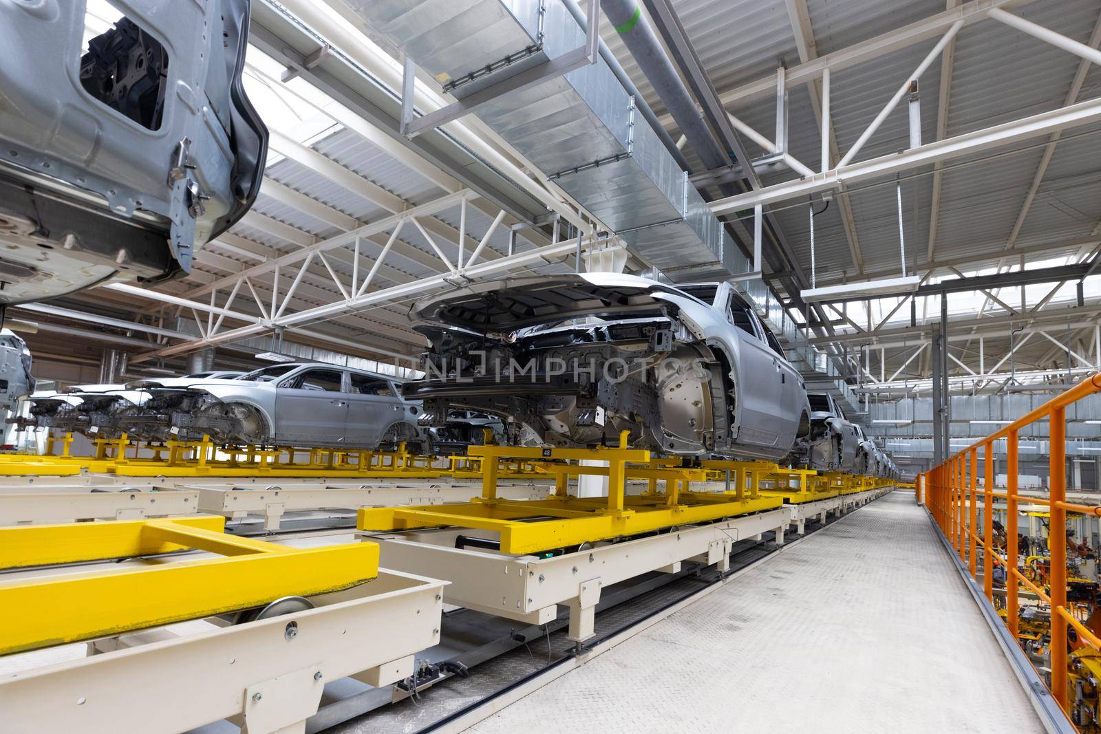 Car bodies are on assembly line. Factory for production of cars. Modern automotive industry.