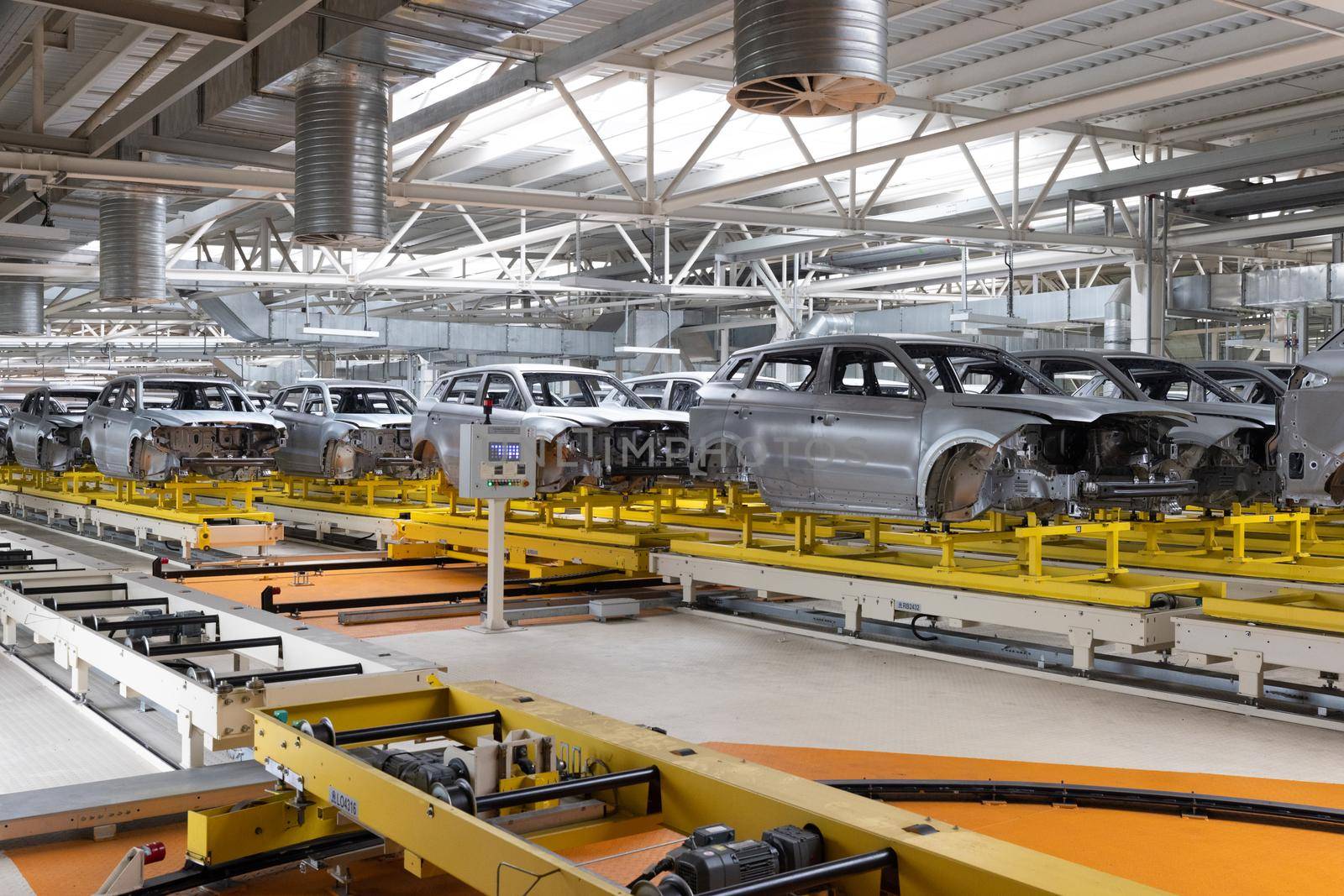 Car bodies are on assembly line. Factory for production of cars. Modern automotive industry.