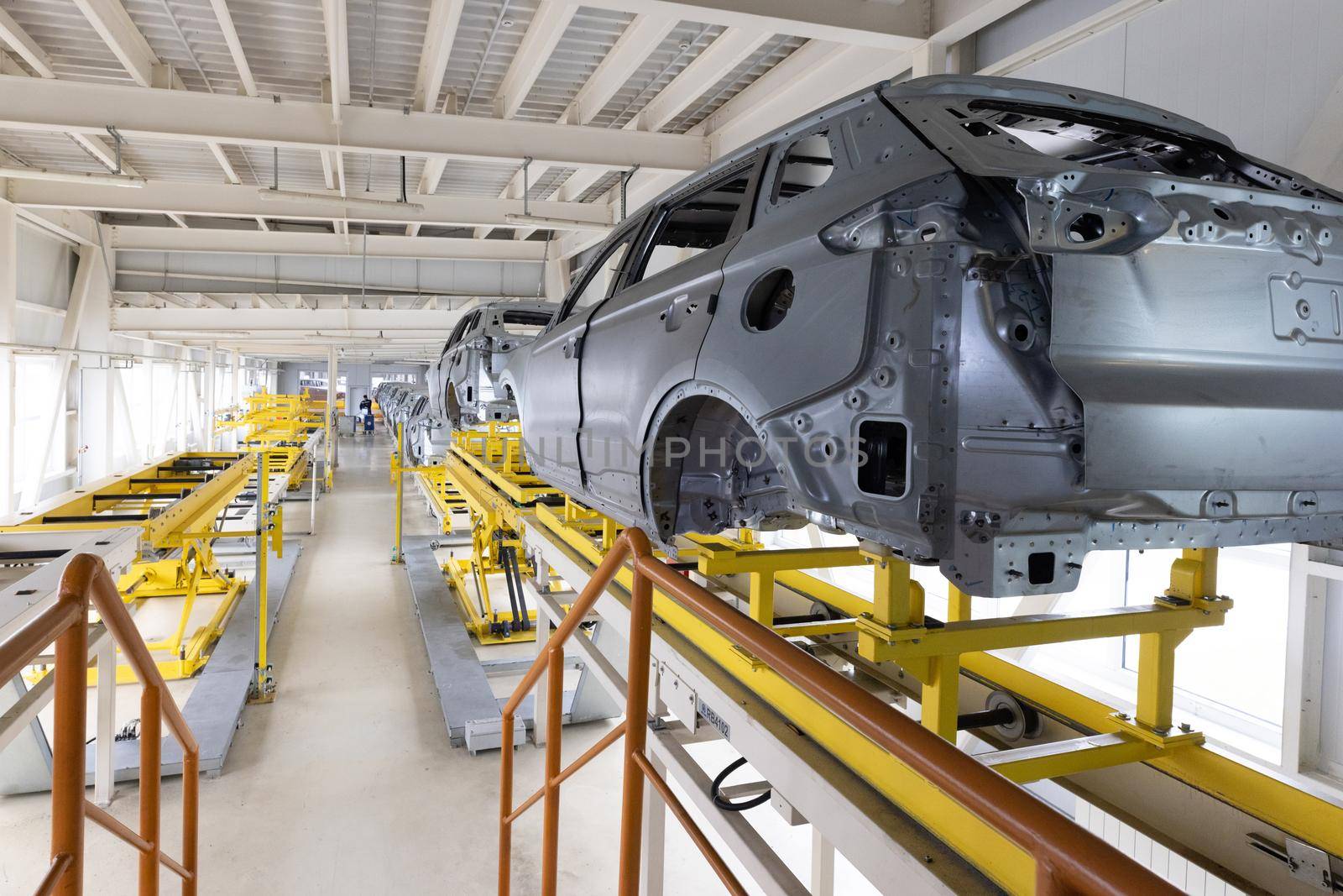 Car bodies are on assembly line. Factory for production of cars. Modern automotive industry. A car being checked before being painted in a high-tech enterprise.
