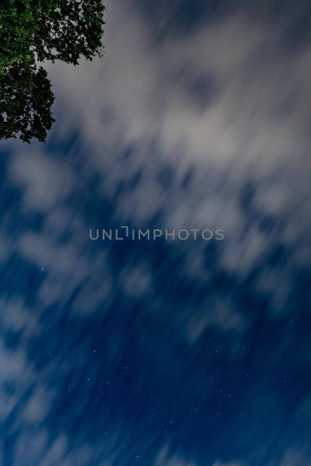 Dark blue sky on long exposure with moving clouds at night 