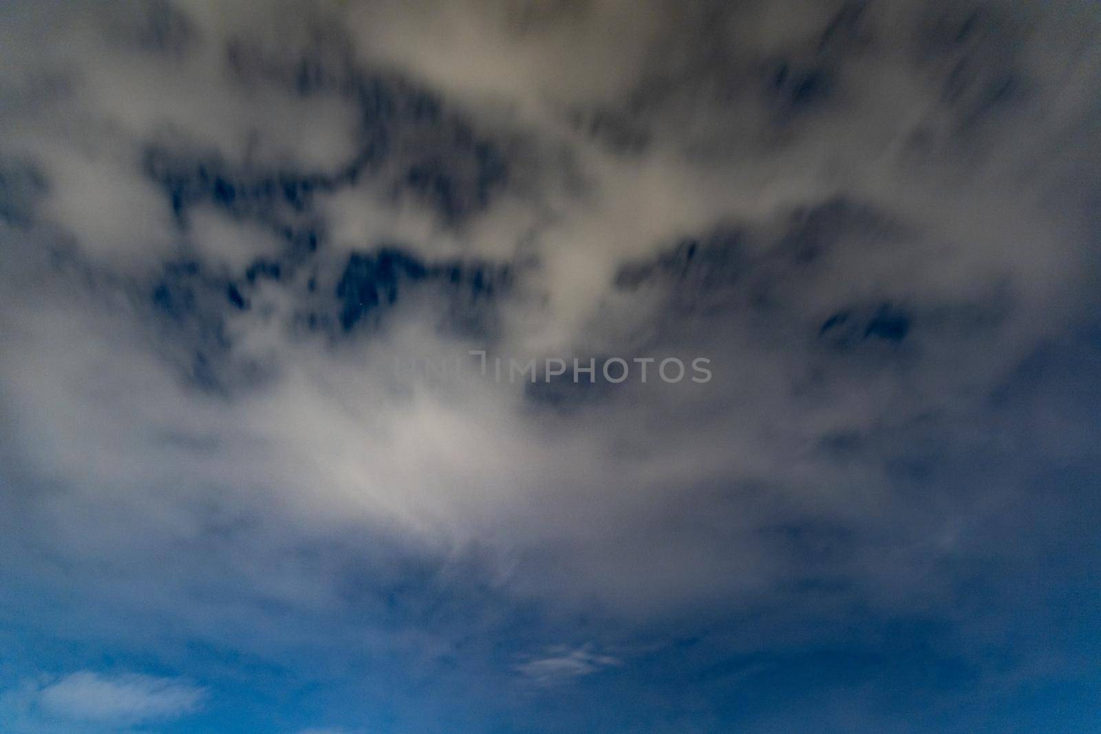 Dark blue sky on long exposure with moving clouds at night 