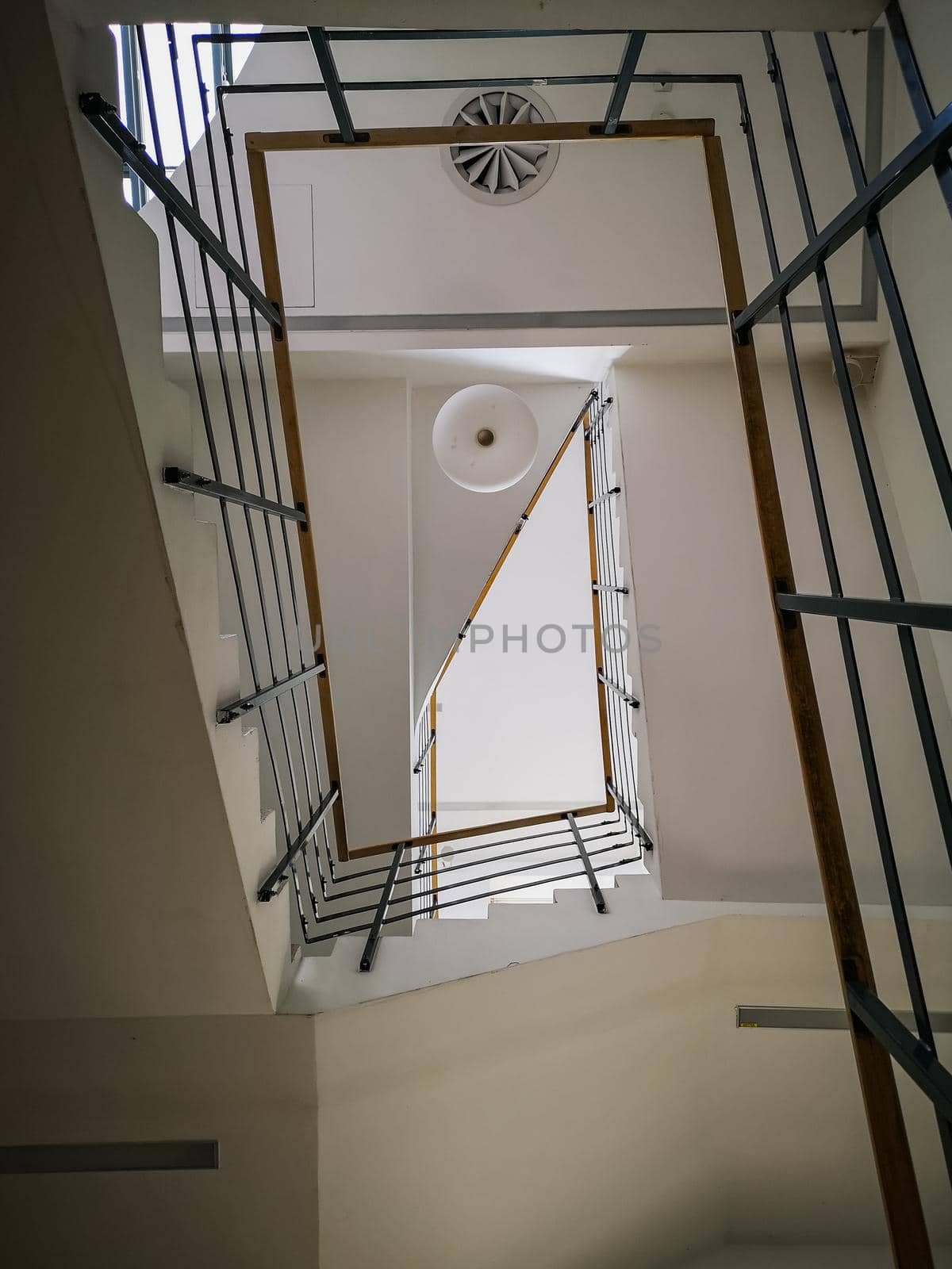 Looking up to Rectangular staircase with light wooden handrail and white ceiling by Wierzchu