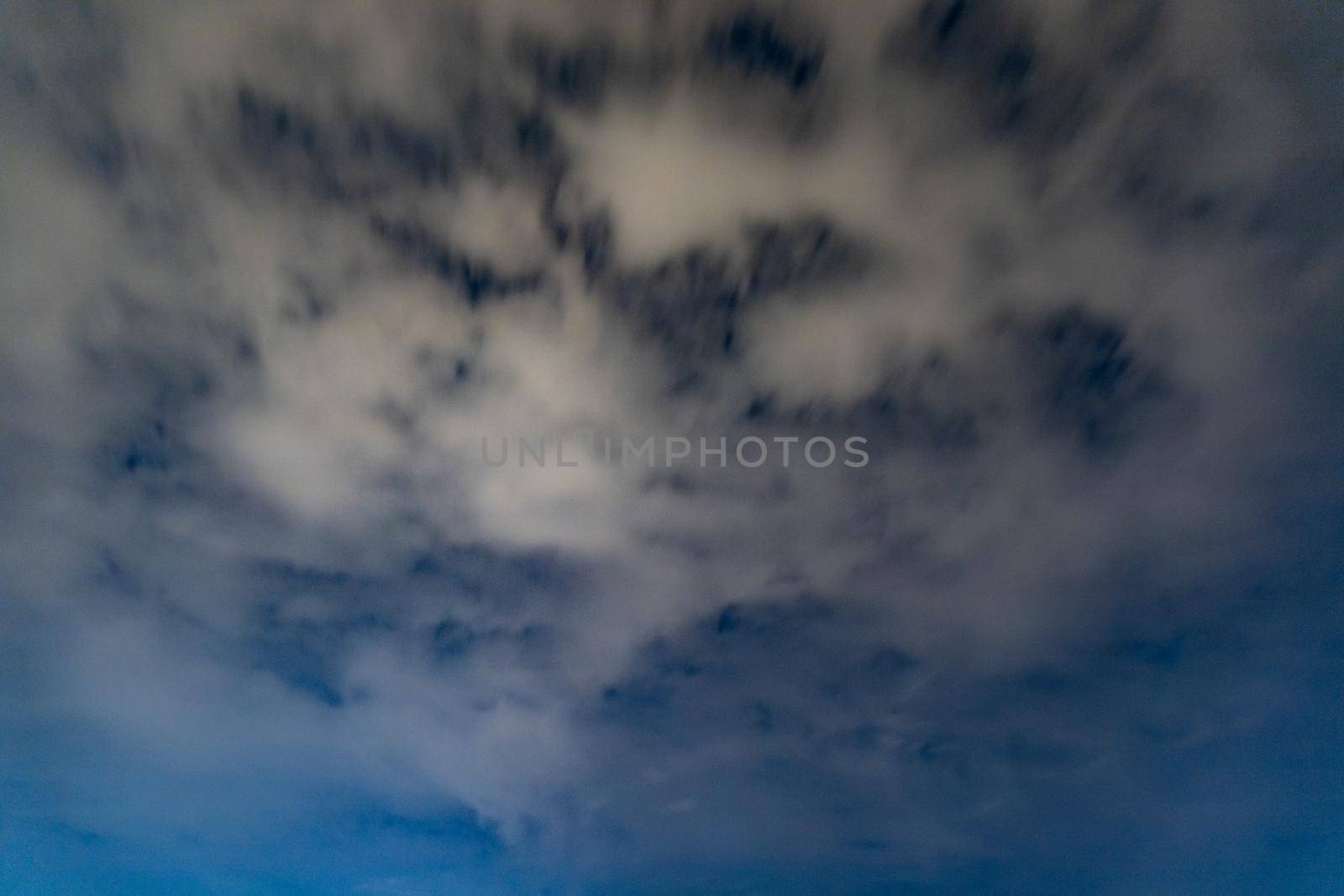 Dark blue sky on long exposure with moving clouds at night 