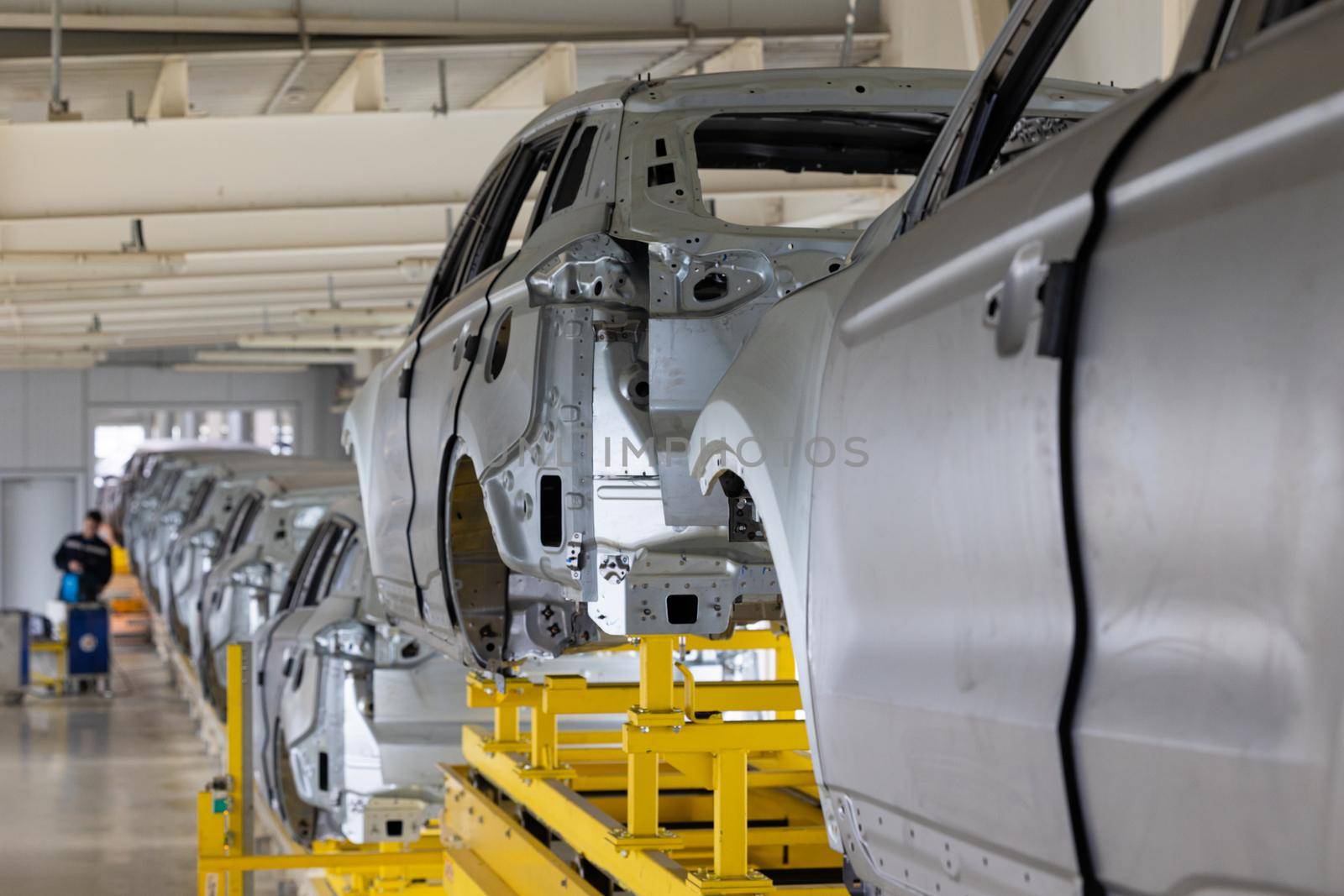 Photo of automobile production line. Modern car assembly plant. Modern and high-tech automotive industry. Conveyor of auto bodies.