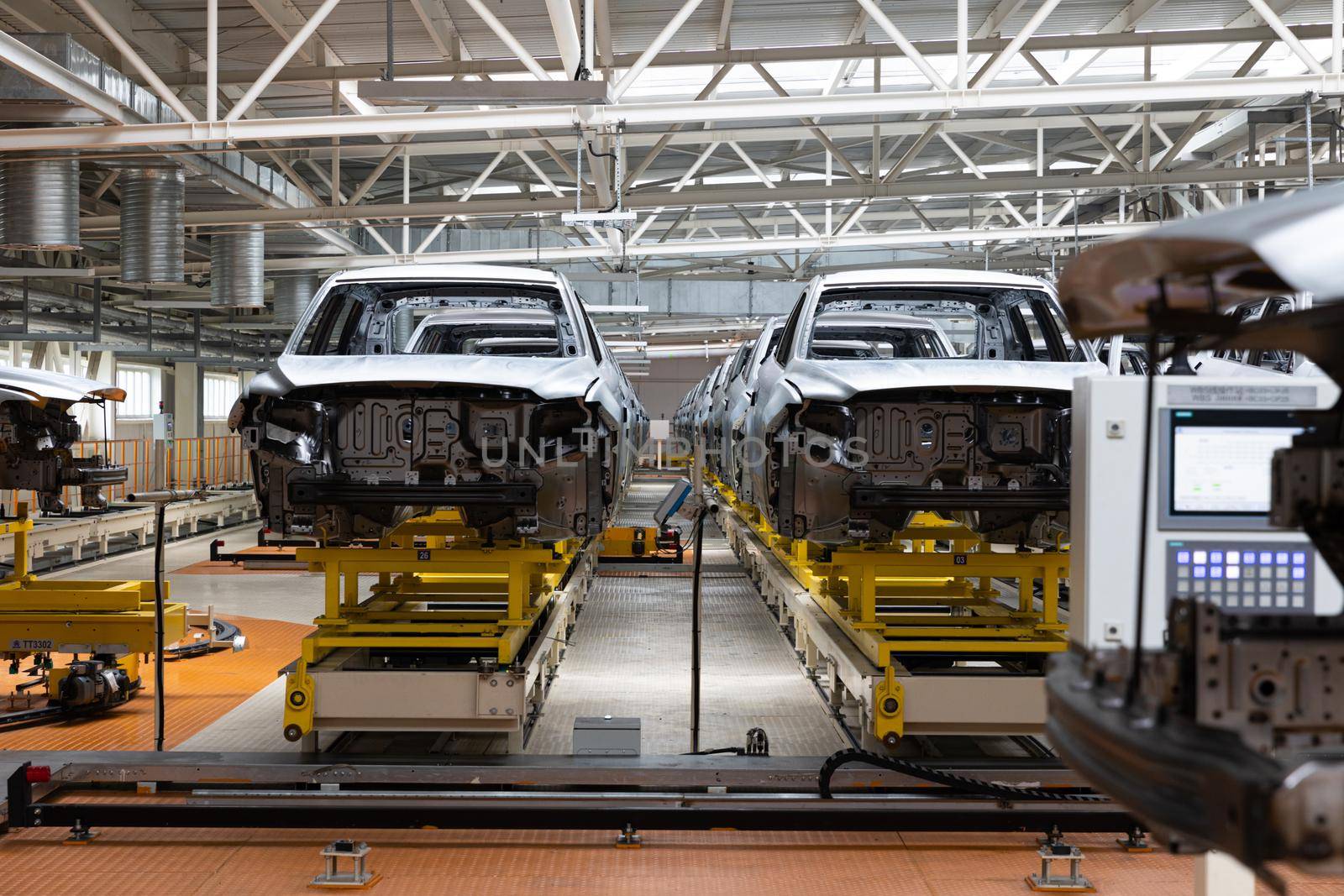 Photo of automobile production line. Modern car assembly plant. Auto industry. Interior of a high-tech factory, modern production.