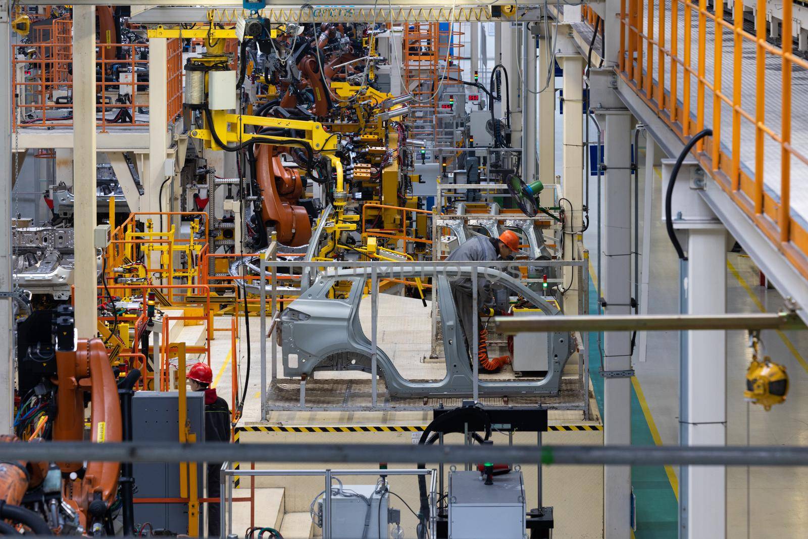 Photo of automobile production line. Welding car body. Modern car assembly plant. Auto industry. Interior of a high-tech factory, modern production.