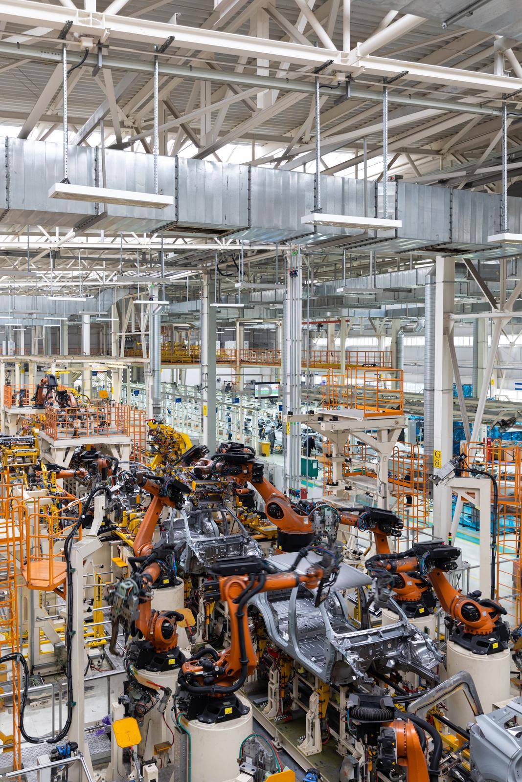 Vertical photo of automobile production line. Modern car assembly plant. Auto industry. Interior of a high-tech factory, modern production by TRMK