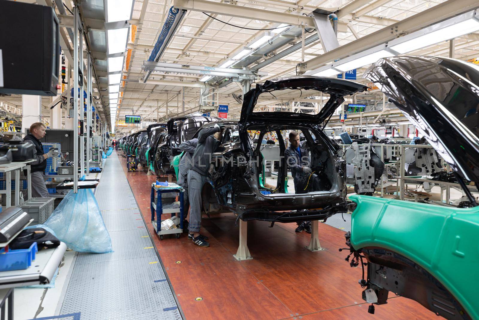 Minsk, Belarus - Dec 15, 2021: Car bodies are on assembly line. Factory for production of cars. Modern automotive industry. A car being checked before being painted in a high-tech enterprise.