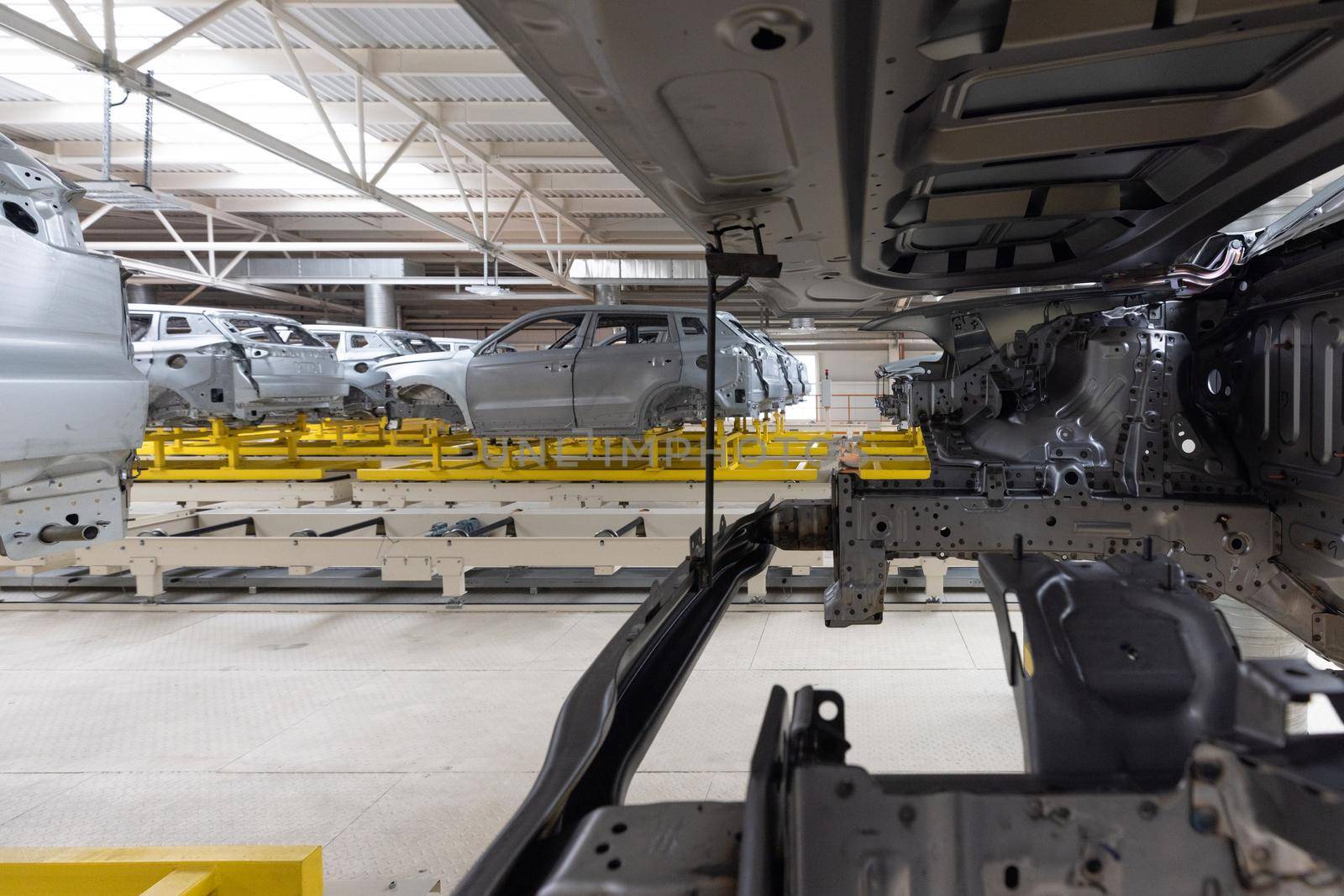 Car bodies are on assembly line. Factory for production of cars. Modern automotive industry.