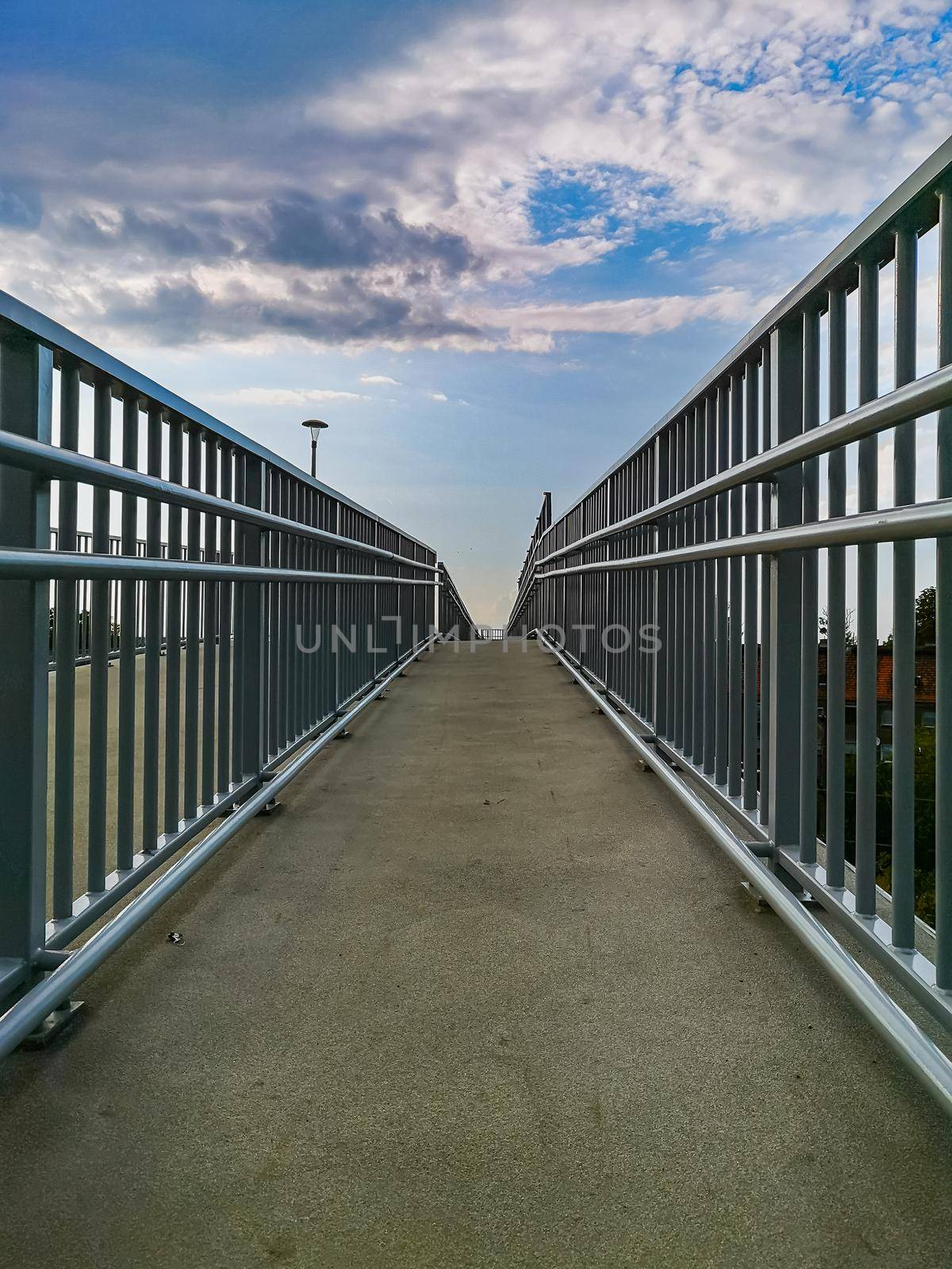 Long high concrete footbridge over city highway by Wierzchu