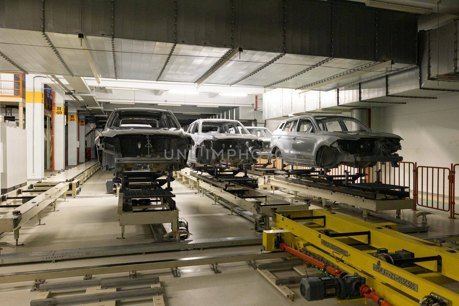 Car bodies are on assembly line. Modern automotive industry. Automobile conveyor. Interior of factory of manufacturing and production.