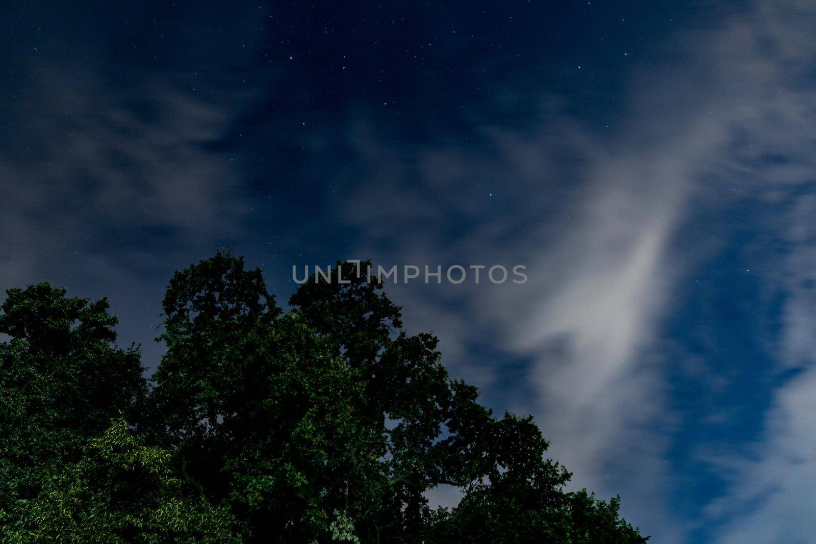 Dark blue sky on long exposure with moving clouds at night 