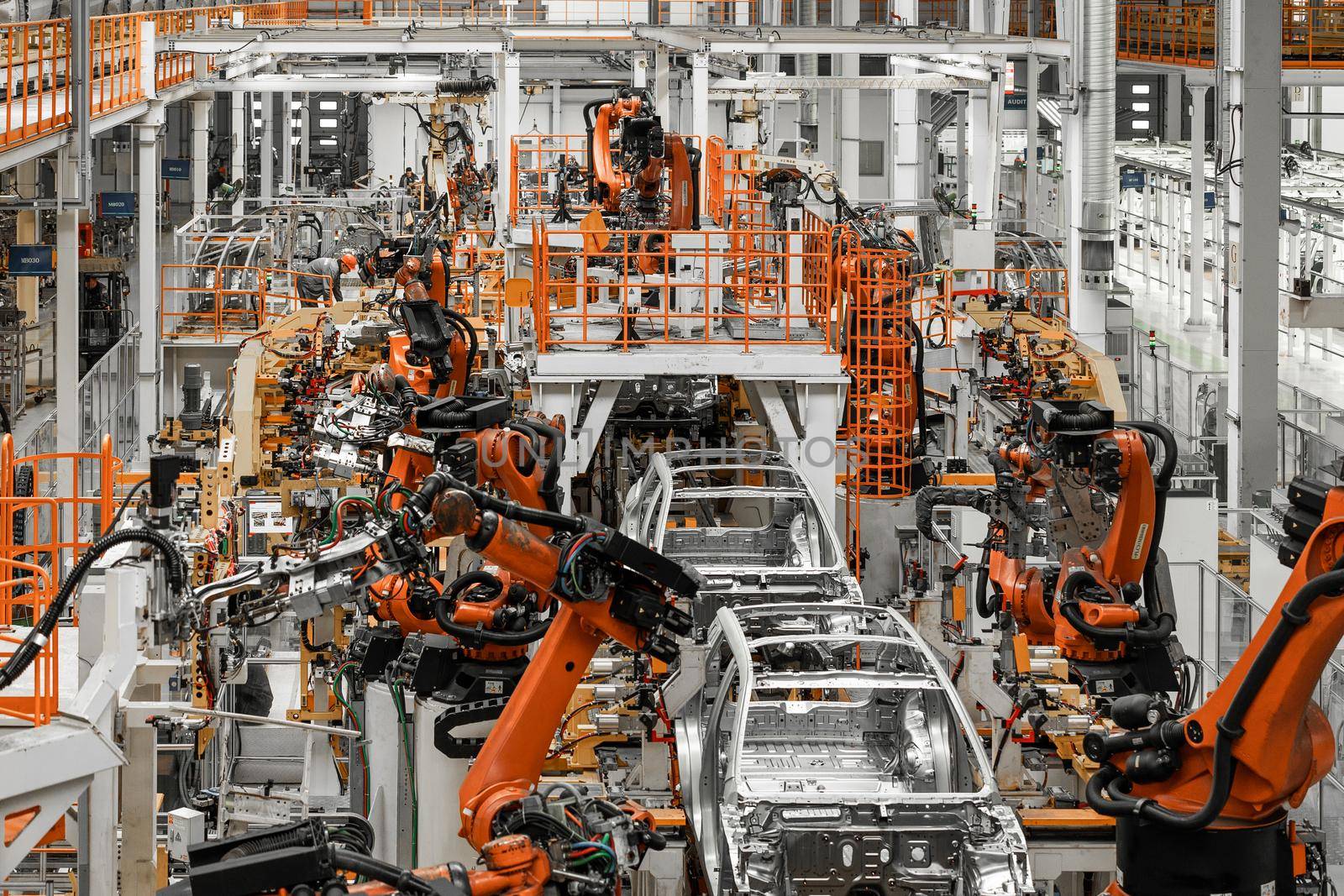 Photo of automobile production line. Welding car body. Modern car assembly plant. Auto industry. Interior of a high-tech factory, modern production.