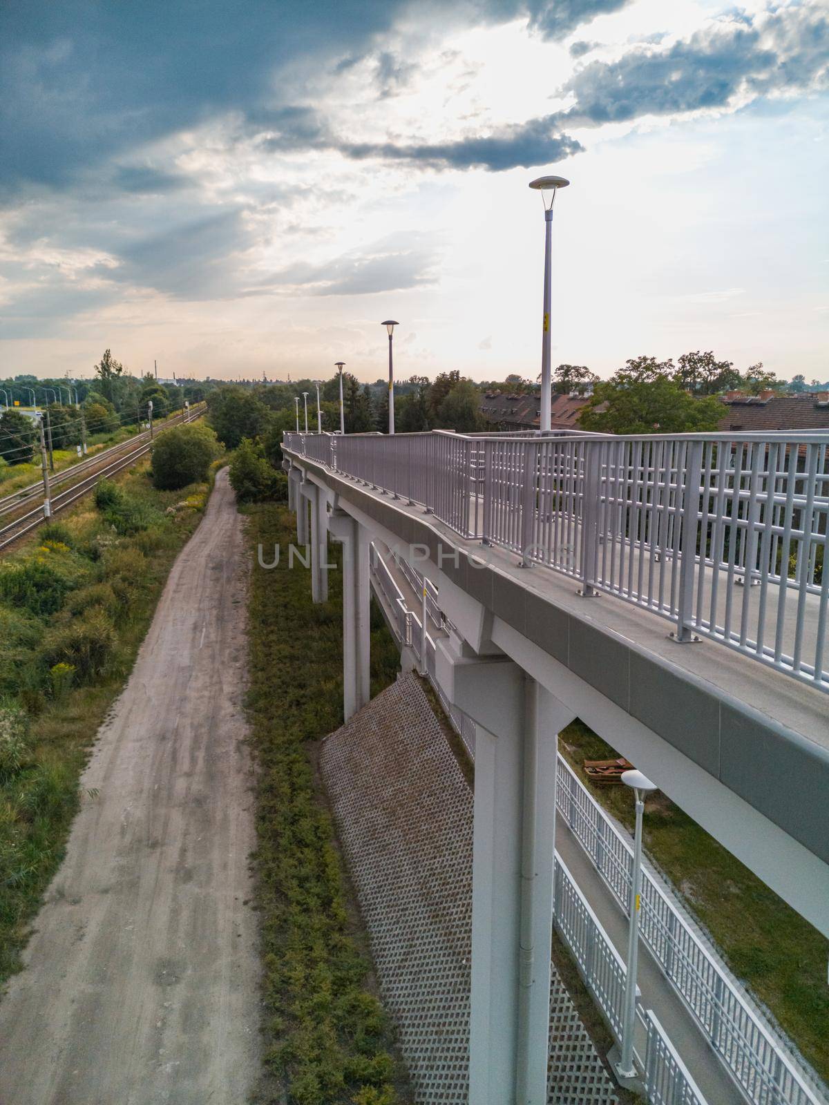 Long high concrete footbridge over city highway by Wierzchu