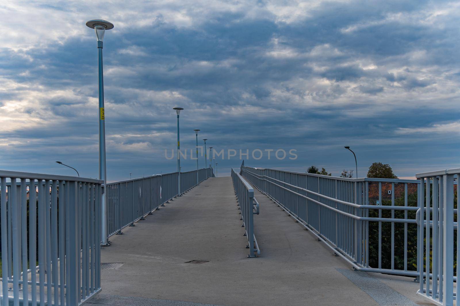 Long high concrete footbridge over city highway