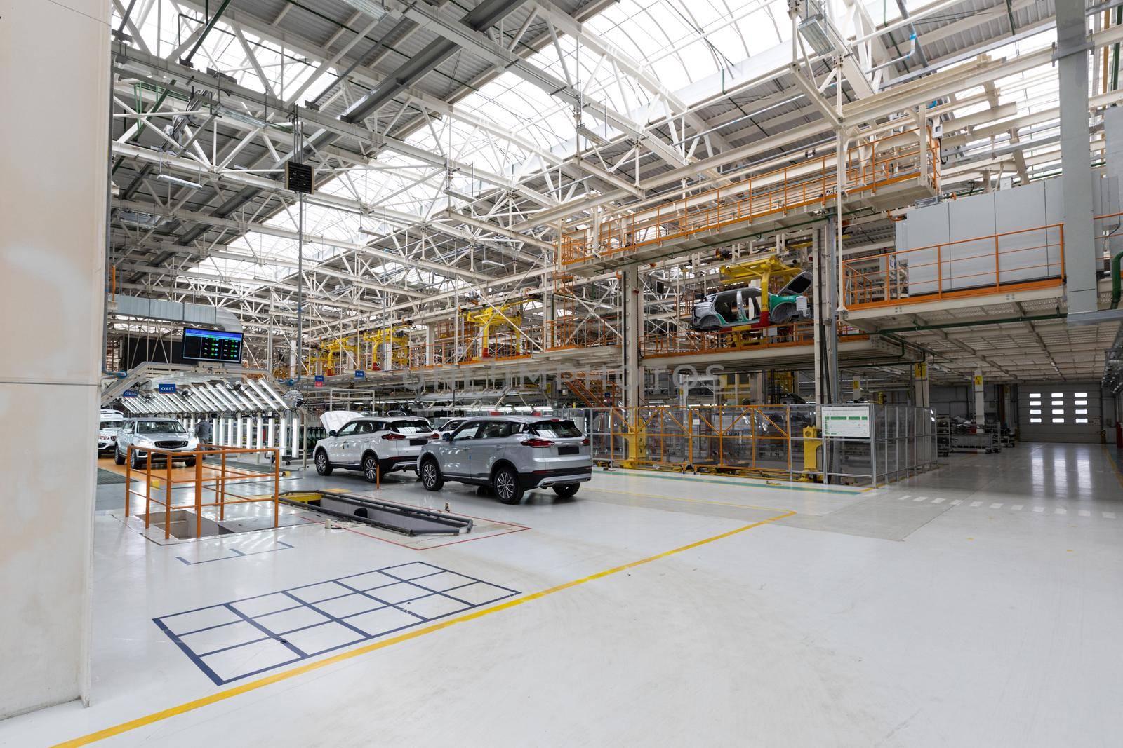 Photo of modern car assembly plant. Interior of a high-tech factory of new automobiles.
