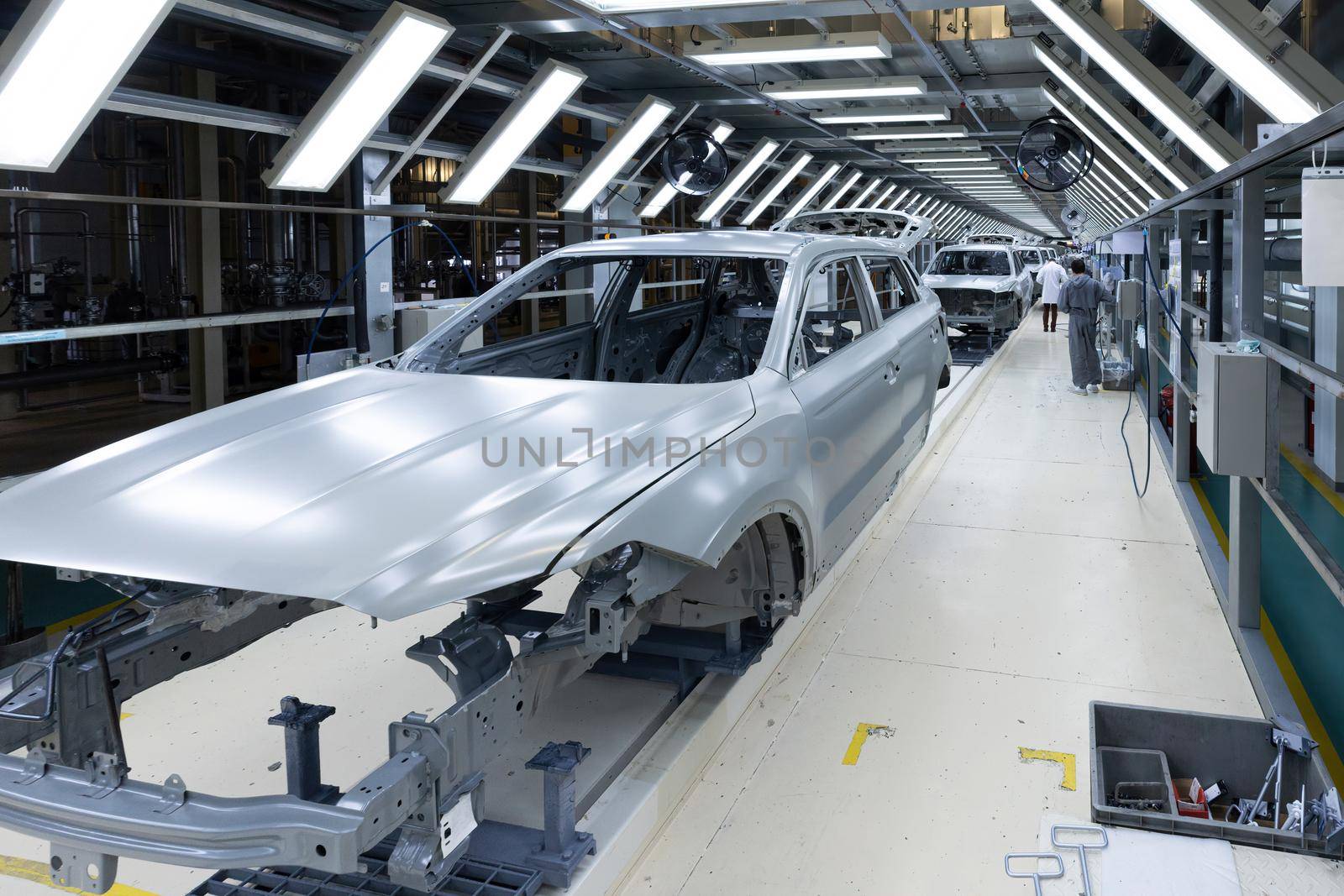 Car bodies are on assembly line. Factory for production of cars. Modern automotive industry.