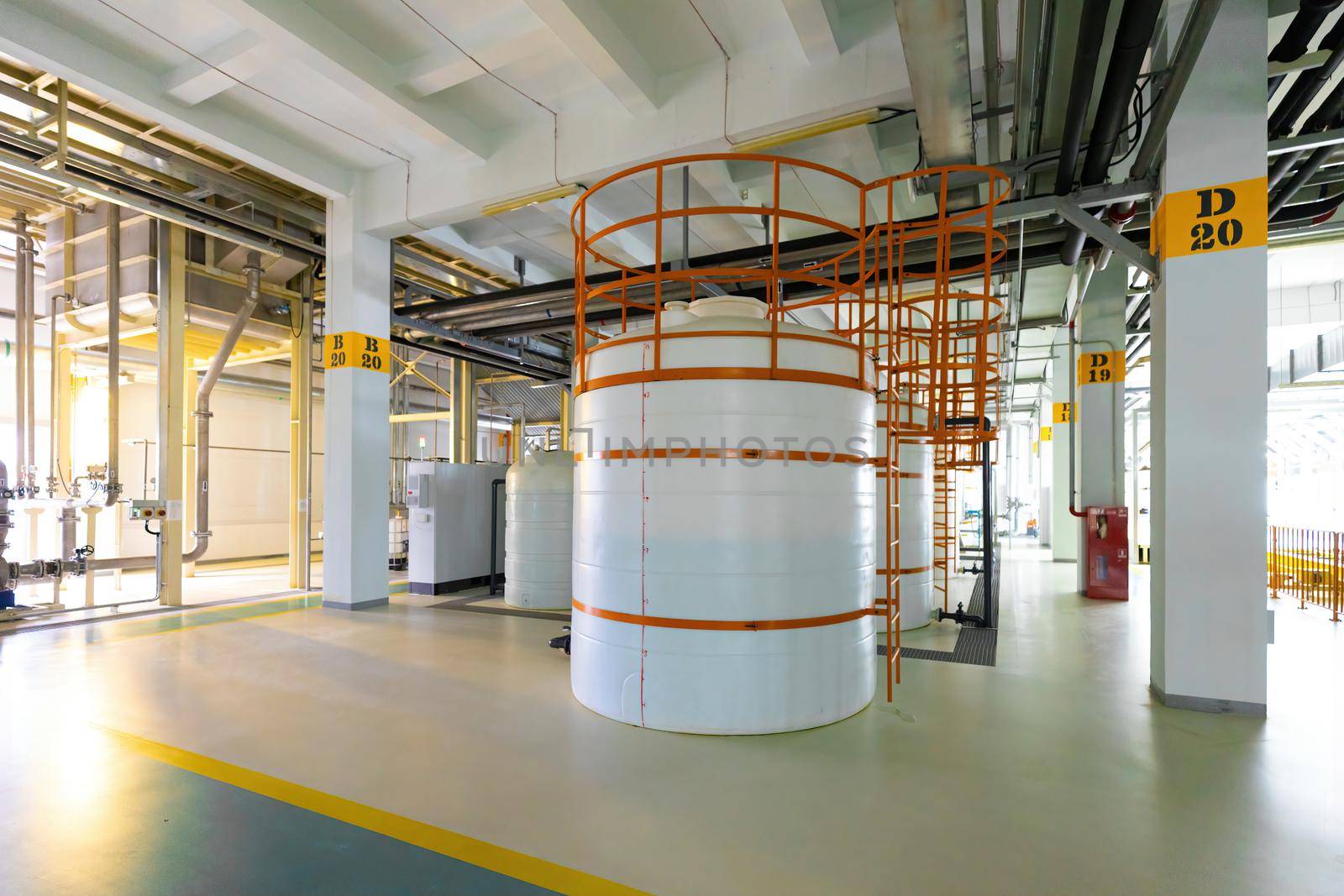 Photo of pipes and white tanks. Chemistry and medicine production. Pharmaceutical factory. Interior of a high-tech factory, modern production.