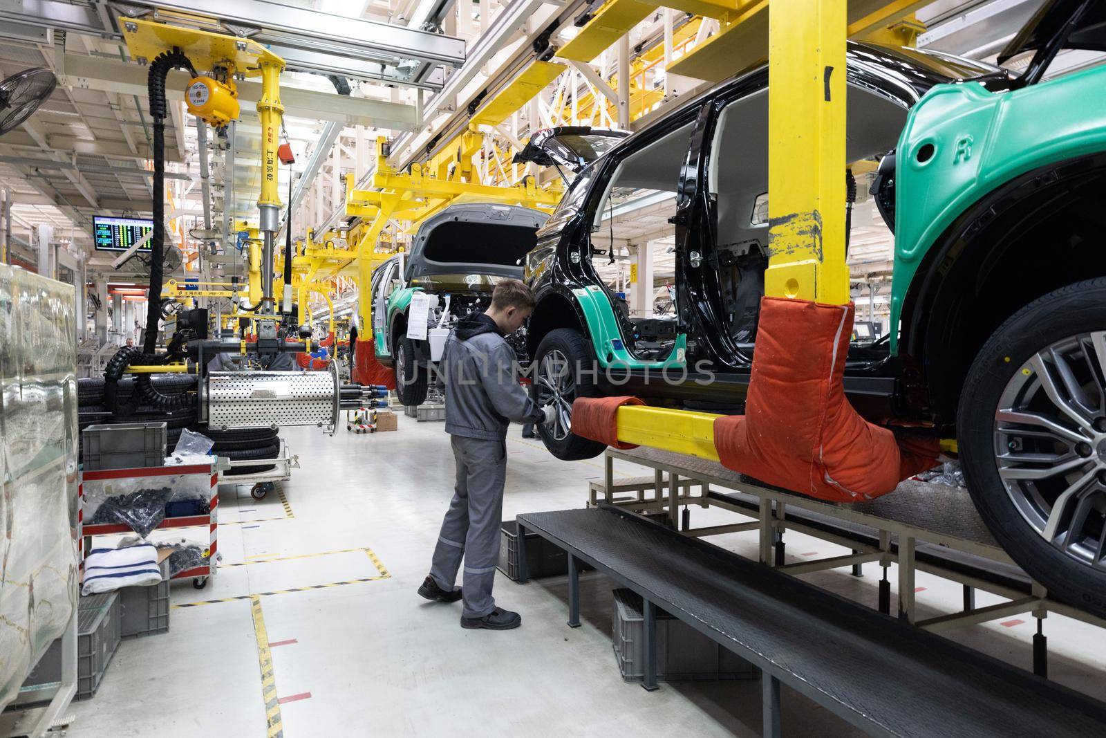 Car bodies are on assembly line. Factory for production of cars. Modern automotive industry. A car being checked before being painted in a high-tech enterprise.