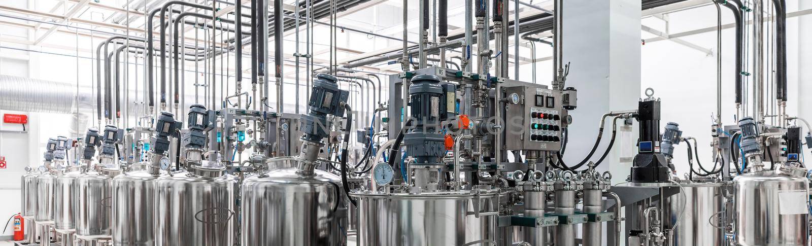 Panoramic photo of pipes and tanks. Chemistry and medicine production. Pharmaceutical factory. Interior of a high-tech factory, modern production.