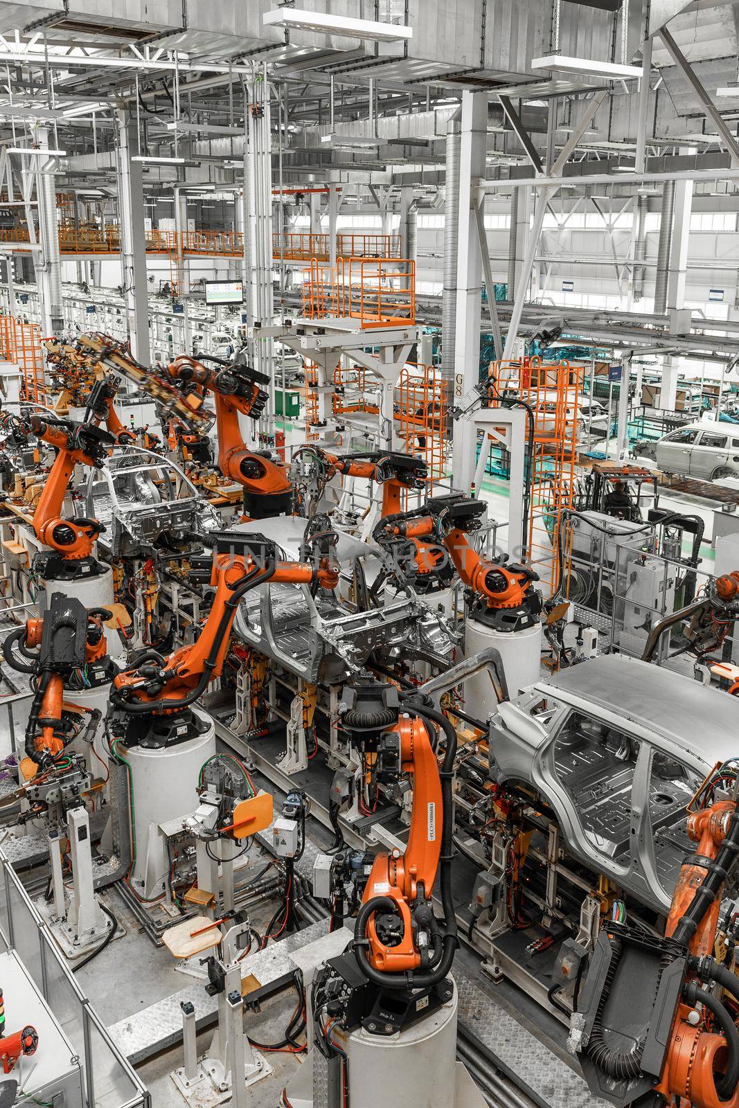 Vertical photo of automobile production line. Modern car assembly plant. Auto industry. Interior of a high-tech factory, modern production.